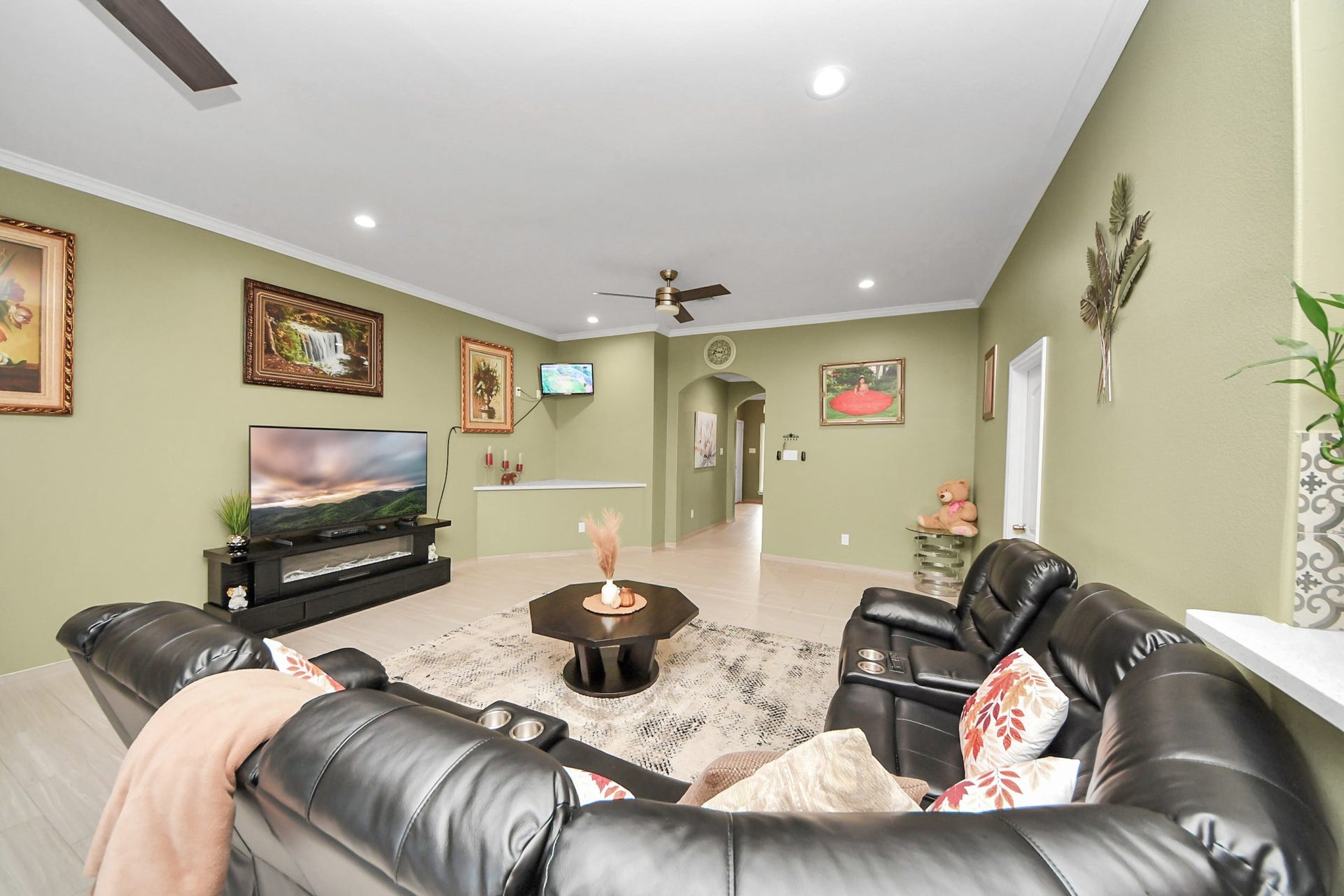Another living room view highlights the tile flooring and ceiling fan.