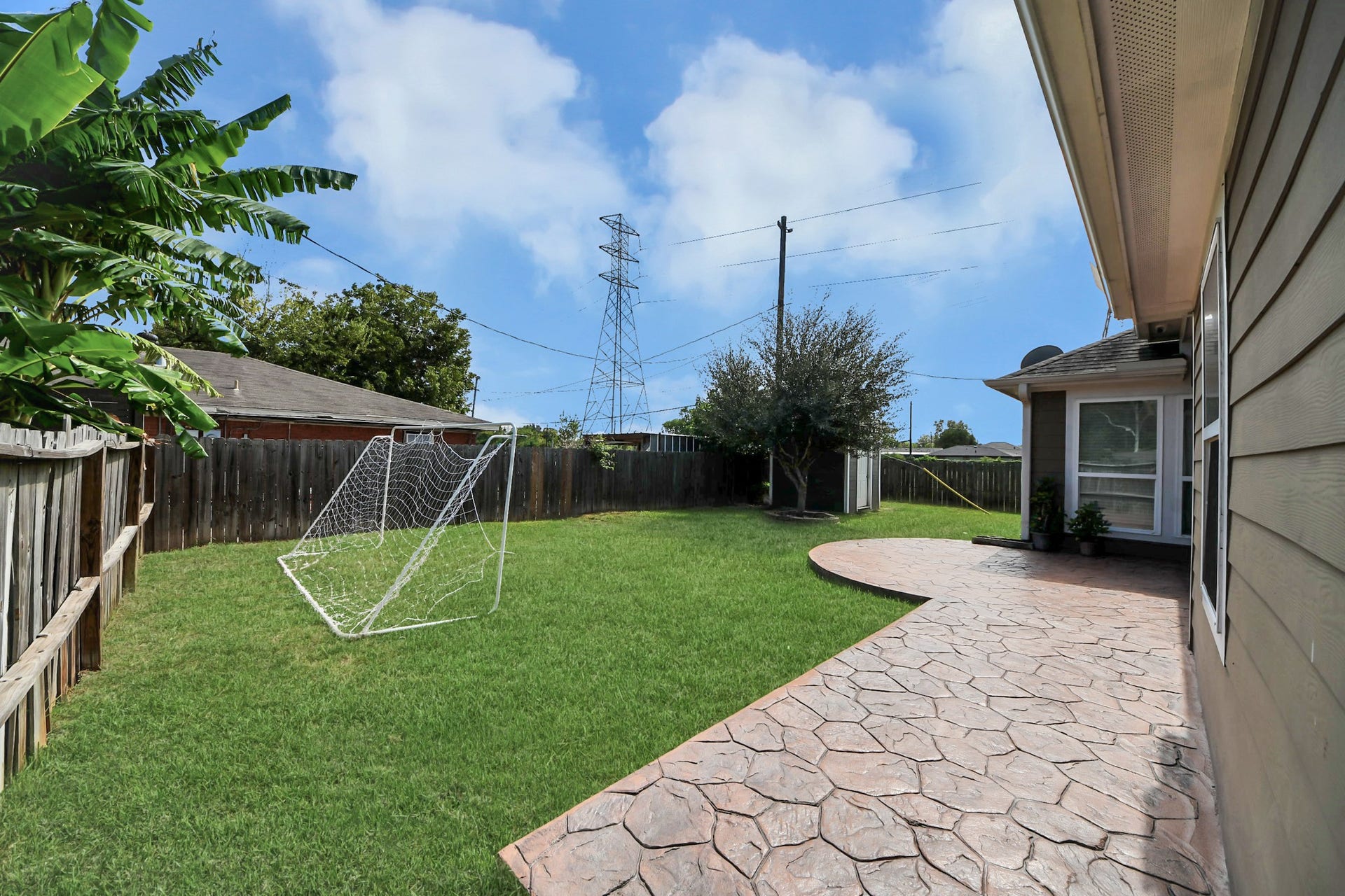 Another backyard angle shows the lawn and patio edge.