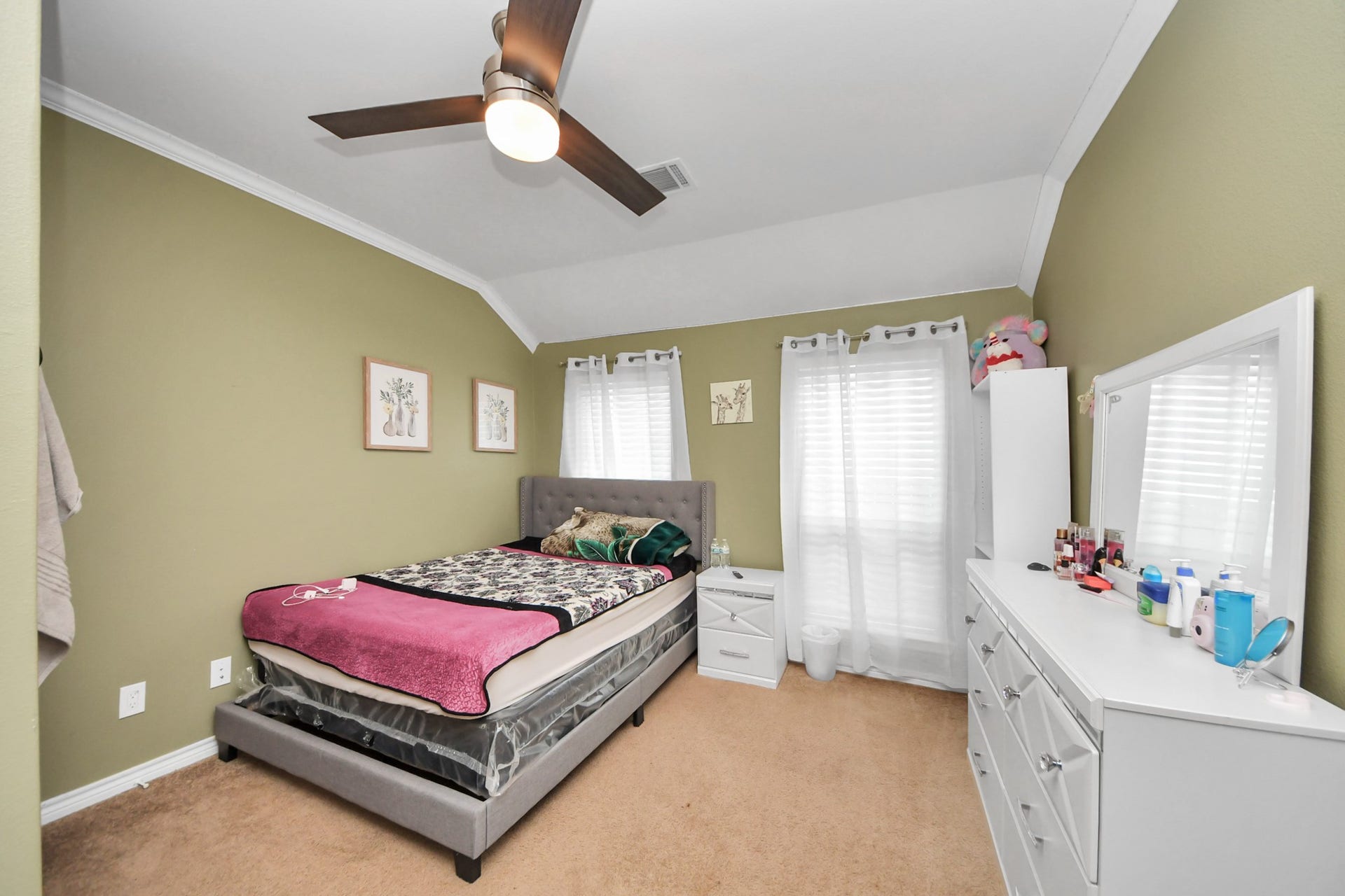 Additional bedroom with tile flooring, windows, and a ceiling fan.