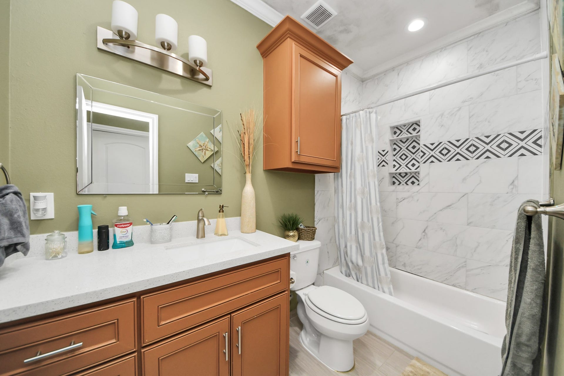 Hall bathroom with a vanity and tiled tub-shower surround.
