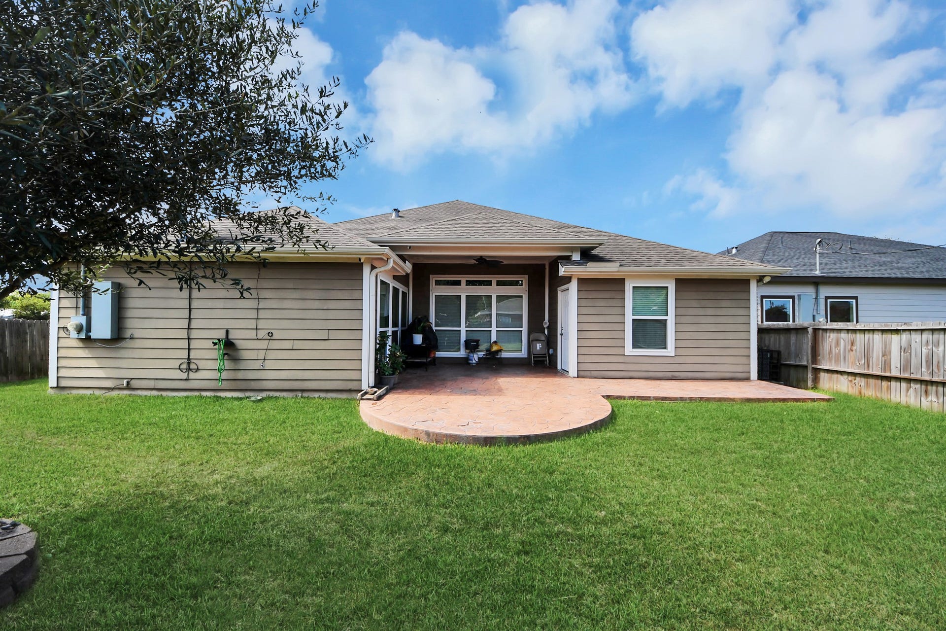 Rear exterior with a covered patio overlooking the backyard.