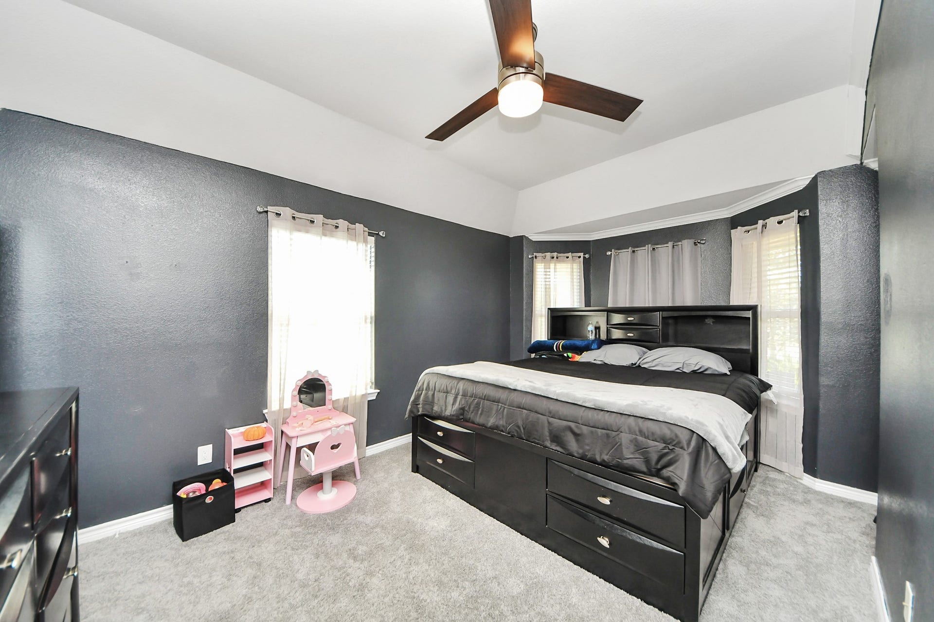 Secondary bedroom with a ceiling fan and natural light.