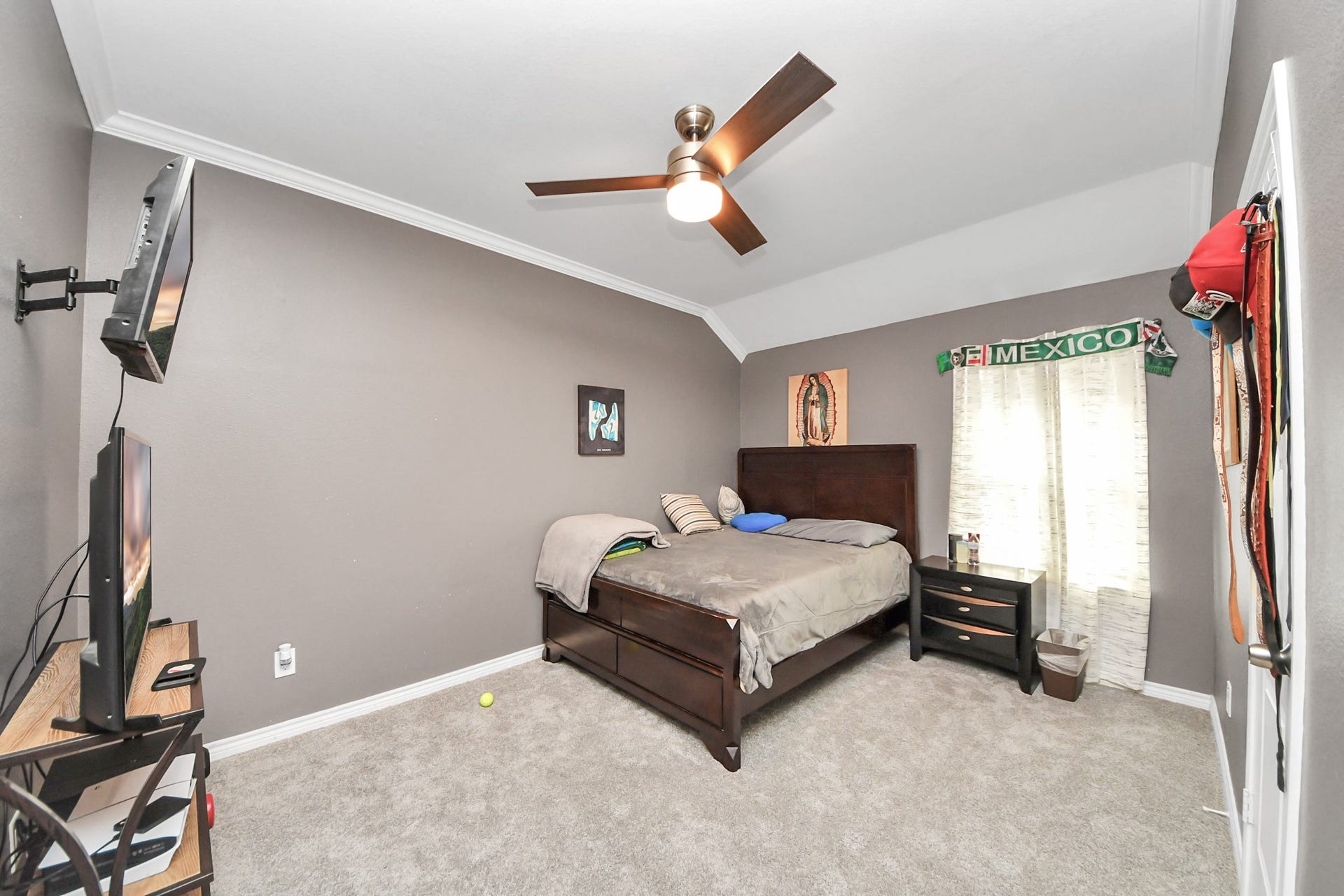 Additional bedroom with a ceiling fan and window light.