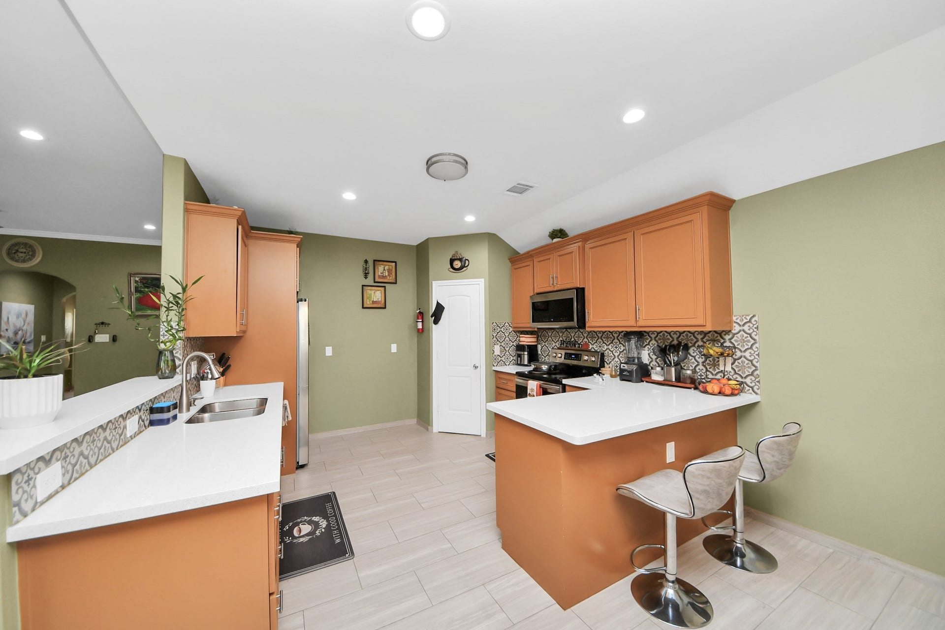 Kitchen with wood cabinetry, tile flooring, and wraparound counters.