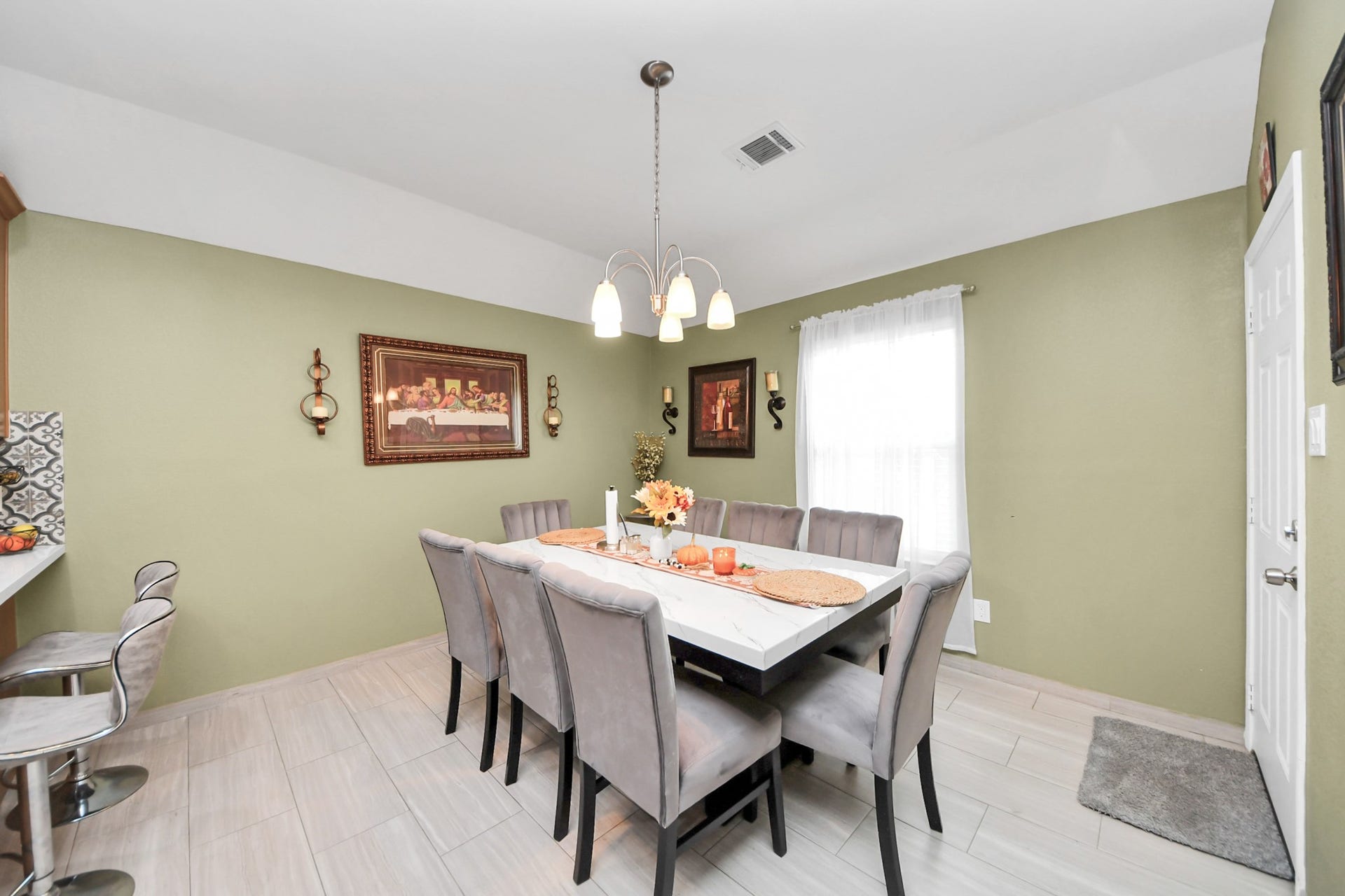 Window-lined dining area with tile flooring and a ceiling fan.
