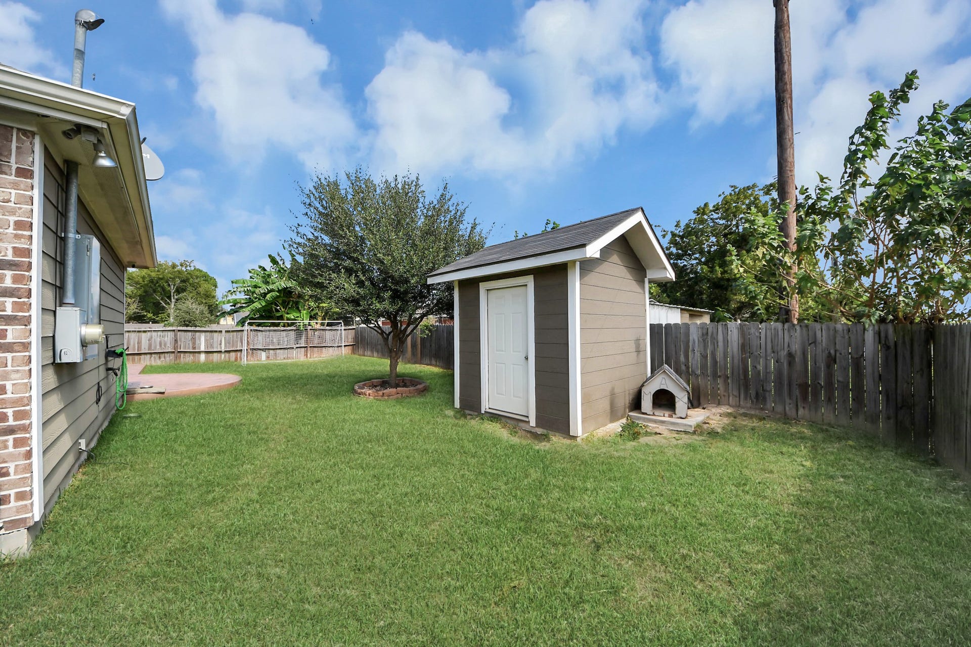 Side yard with lawn alongside the home and outbuilding.