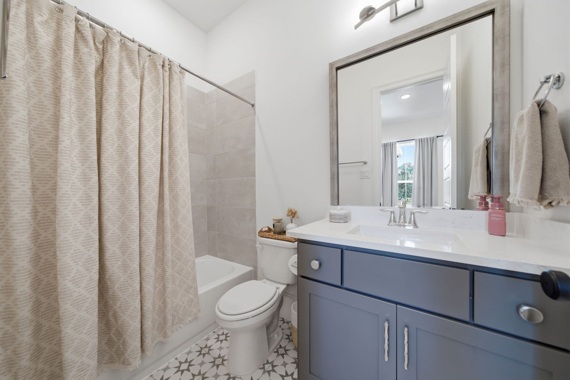 6310 Star Light Court, Spring, TX 77386 Charming bathroom with a modern vanity, elegant tile flooring, and a cozy tub-shower combo, creating a stylish and functional space.