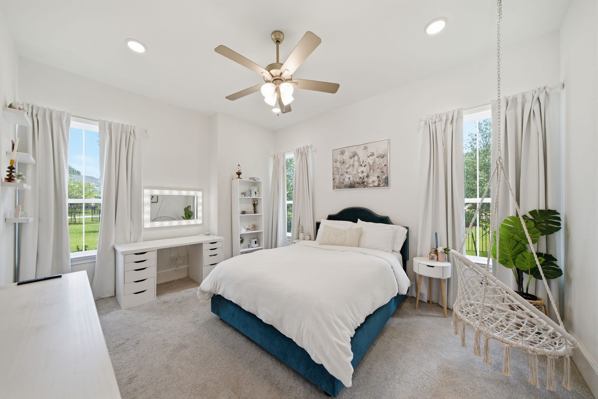 6310 Star Light Court, Spring, TX 77386 Bright and inviting bedroom with large windows, a cozy bed, and a charming hanging chair, offering a perfect blend of comfort and style.