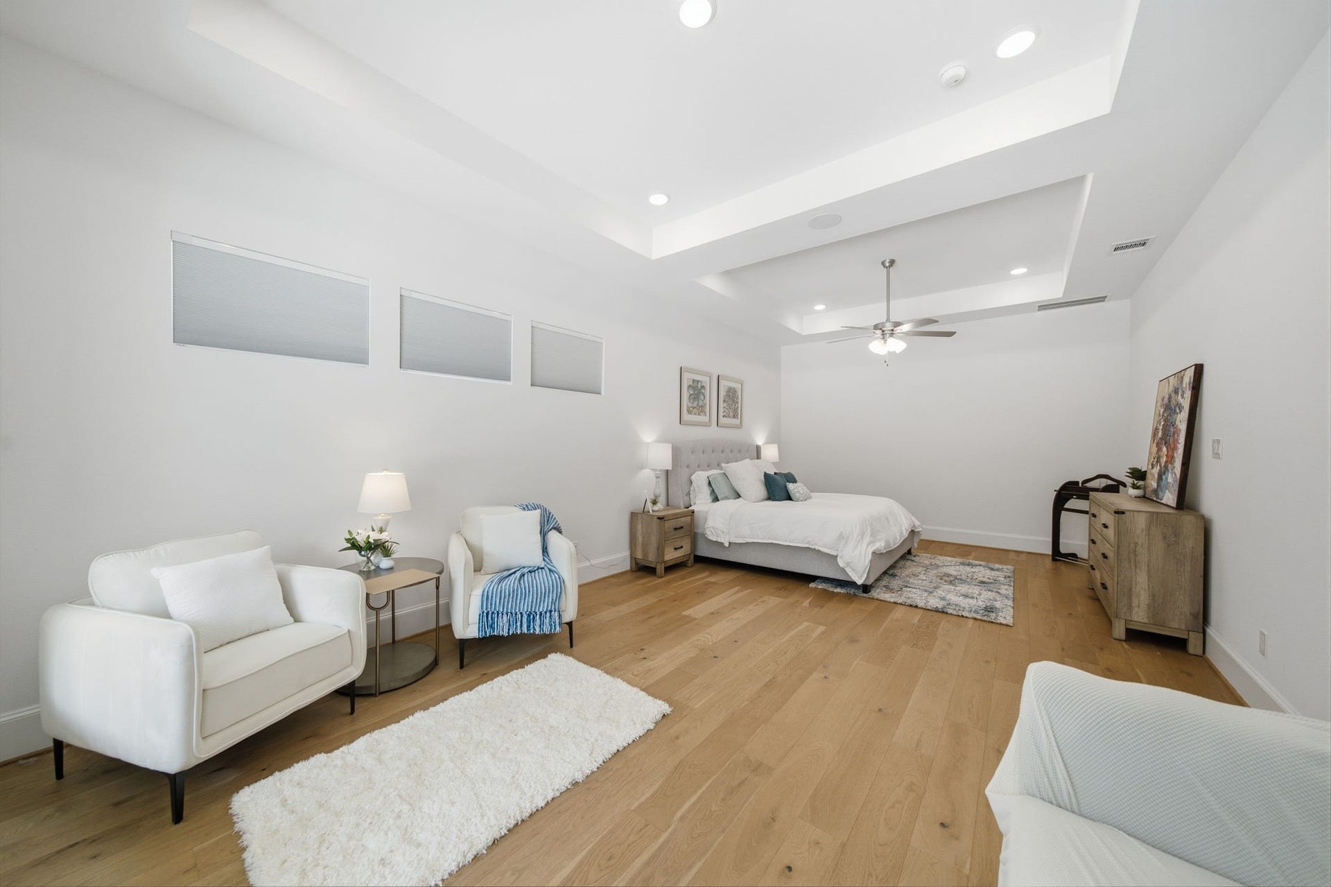 6310 Star Light Court, Spring, TX 77386 Spacious and elegant bedroom with hardwood floors, recessed lighting, and a cozy sitting area, offering a serene retreat.