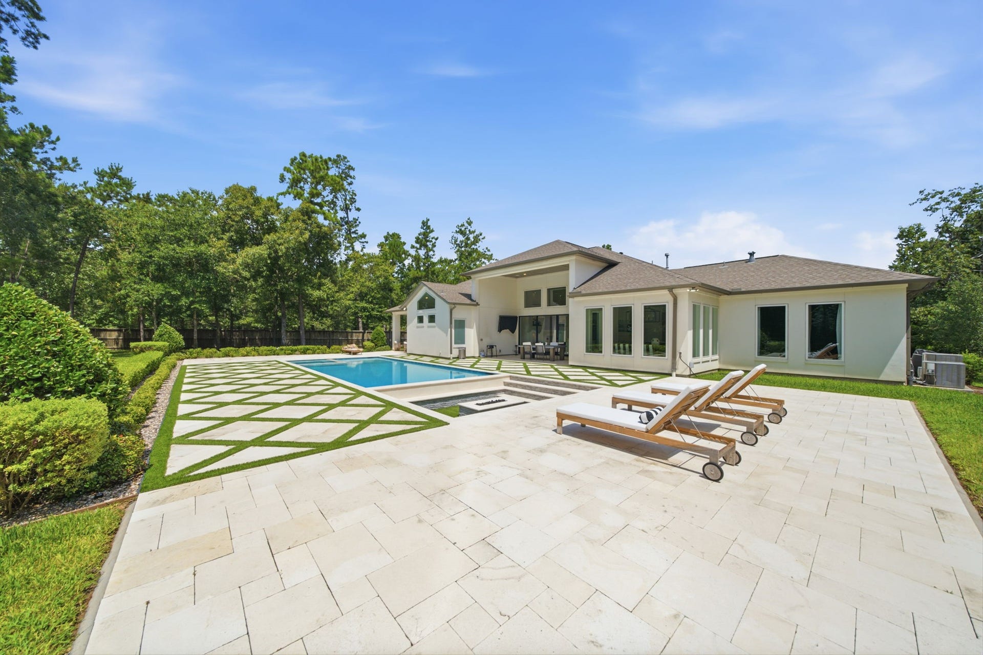 6310 Star Light Court, Spring, TX 77386 Luxurious modern home with a spacious backyard featuring a pristine pool, elegant patio, and lush landscaping, perfect for outdoor relaxation and entertaining.
