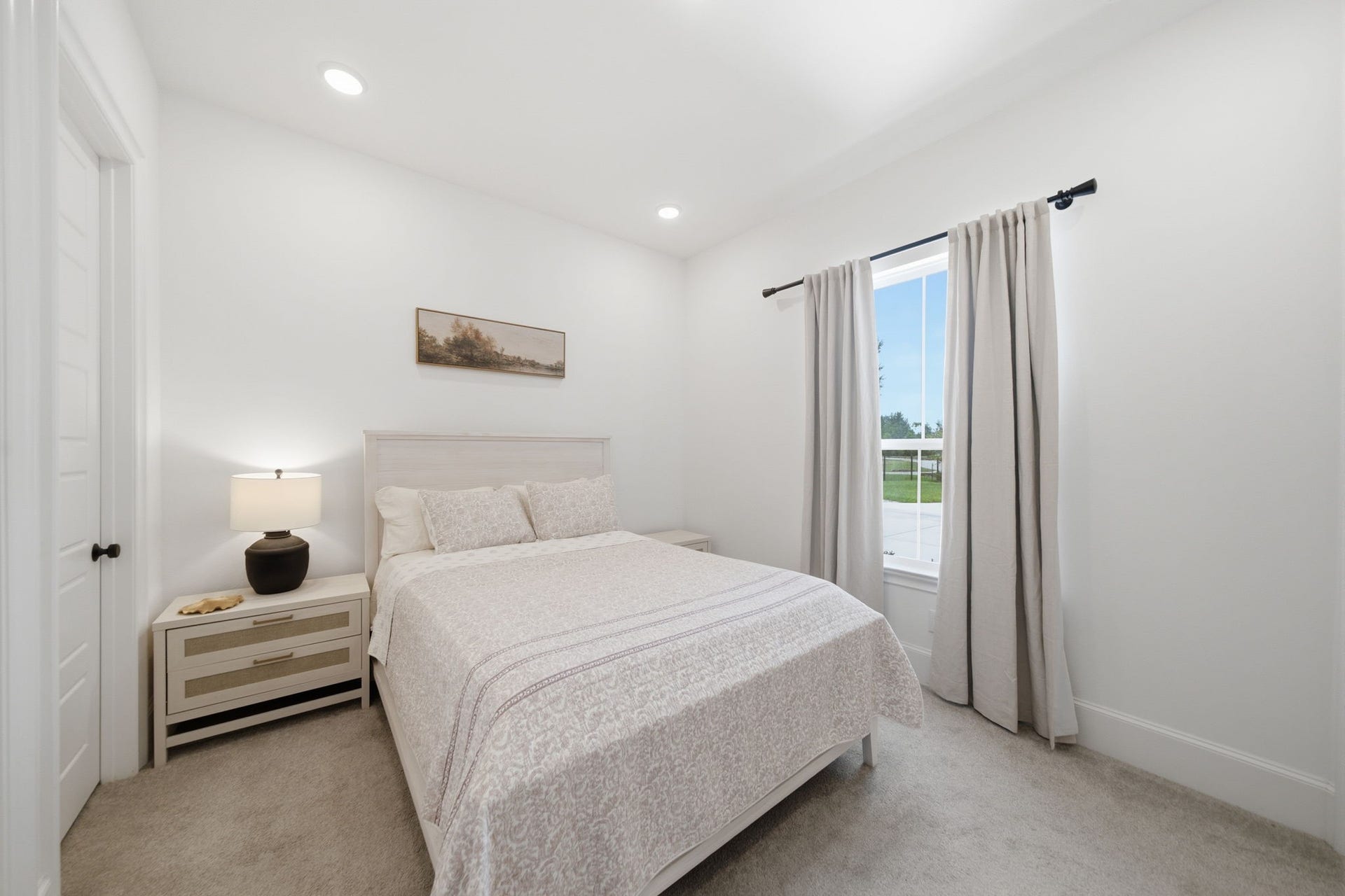 6310 Star Light Court, Spring, TX 77386 Bright and inviting bedroom featuring a cozy bed, soft carpeting, and a large window with elegant drapes, offering plenty of natural light.