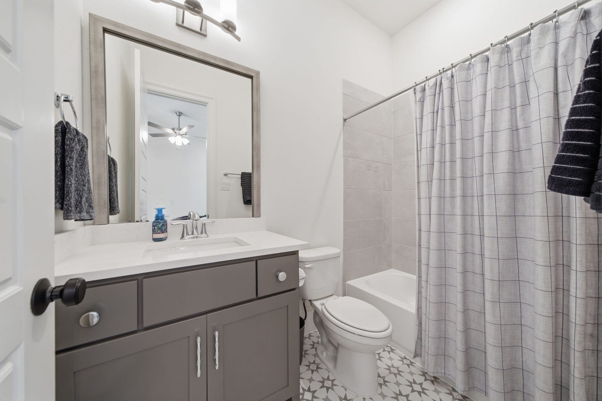 6310 Star Light Court, Spring, TX 77386 Modern bathroom with a sleek vanity, contemporary fixtures, and a stylish patterned tile floor.
