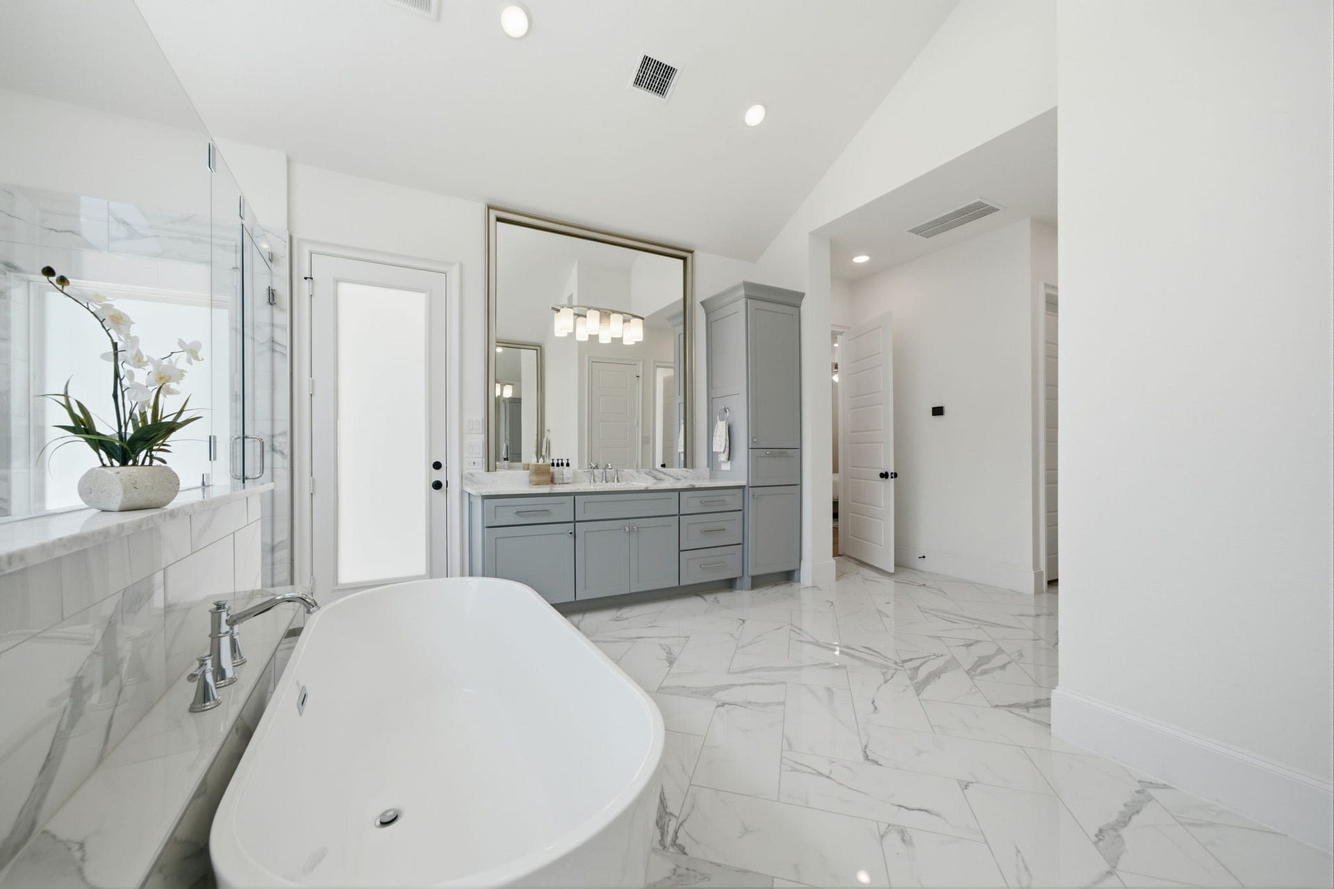 6310 Star Light Court, Spring, TX 77386 Luxurious bathroom featuring a freestanding tub, elegant marble flooring, and a sleek vanity with ample storage, all enhanced by soft natural lighting.