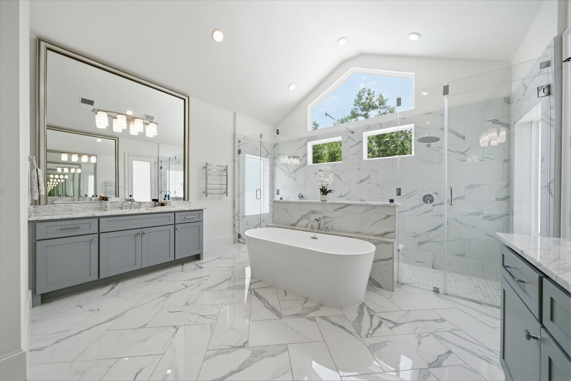 6310 Star Light Court, Spring, TX 77386 Luxurious bathroom featuring a freestanding tub, spacious glass-enclosed shower, and elegant double vanity with marble countertops.