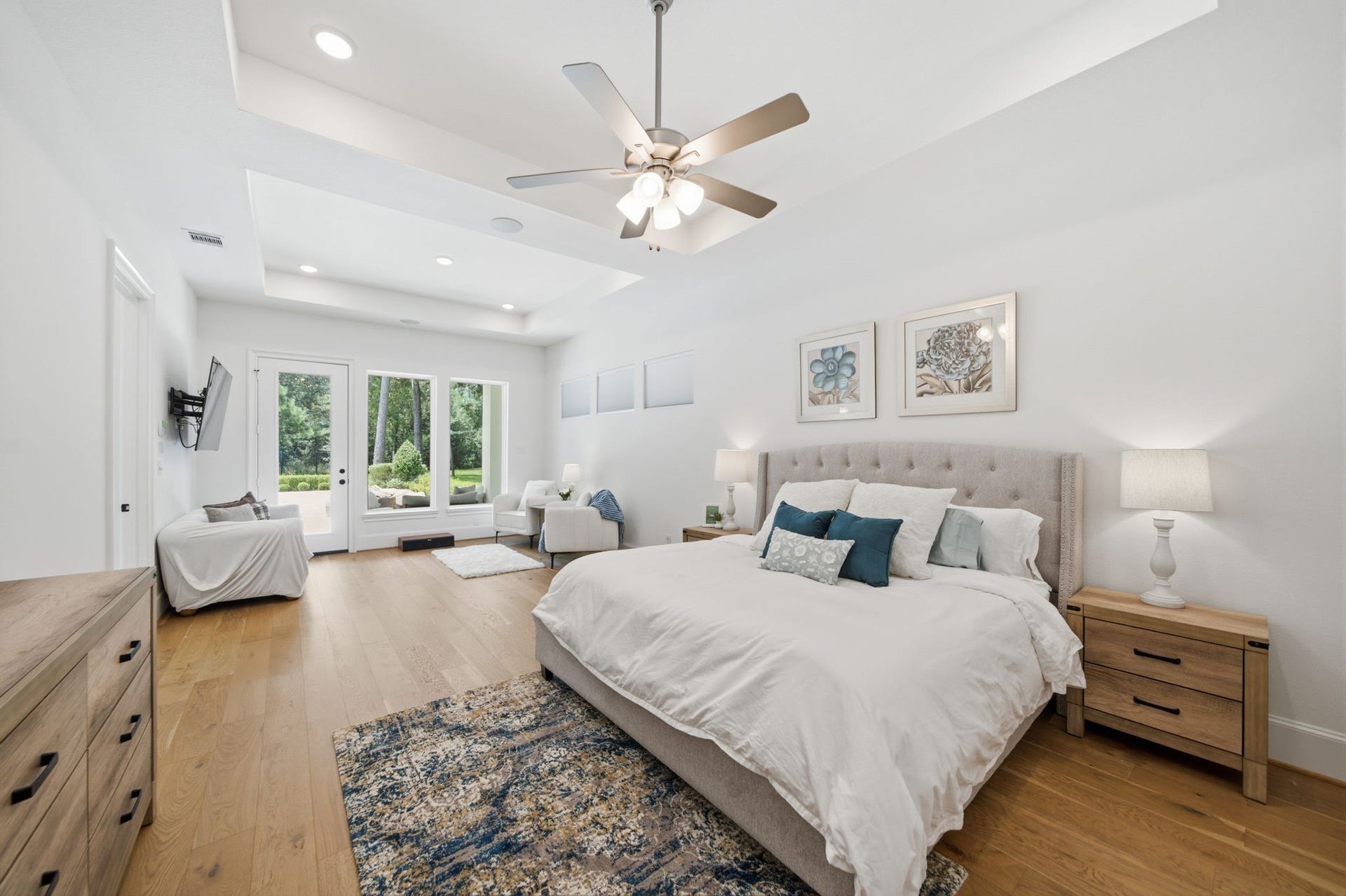 6310 Star Light Court, Spring, TX 77386 Spacious and bright bedroom with elegant tray ceiling, hardwood floors, and large windows offering serene views.