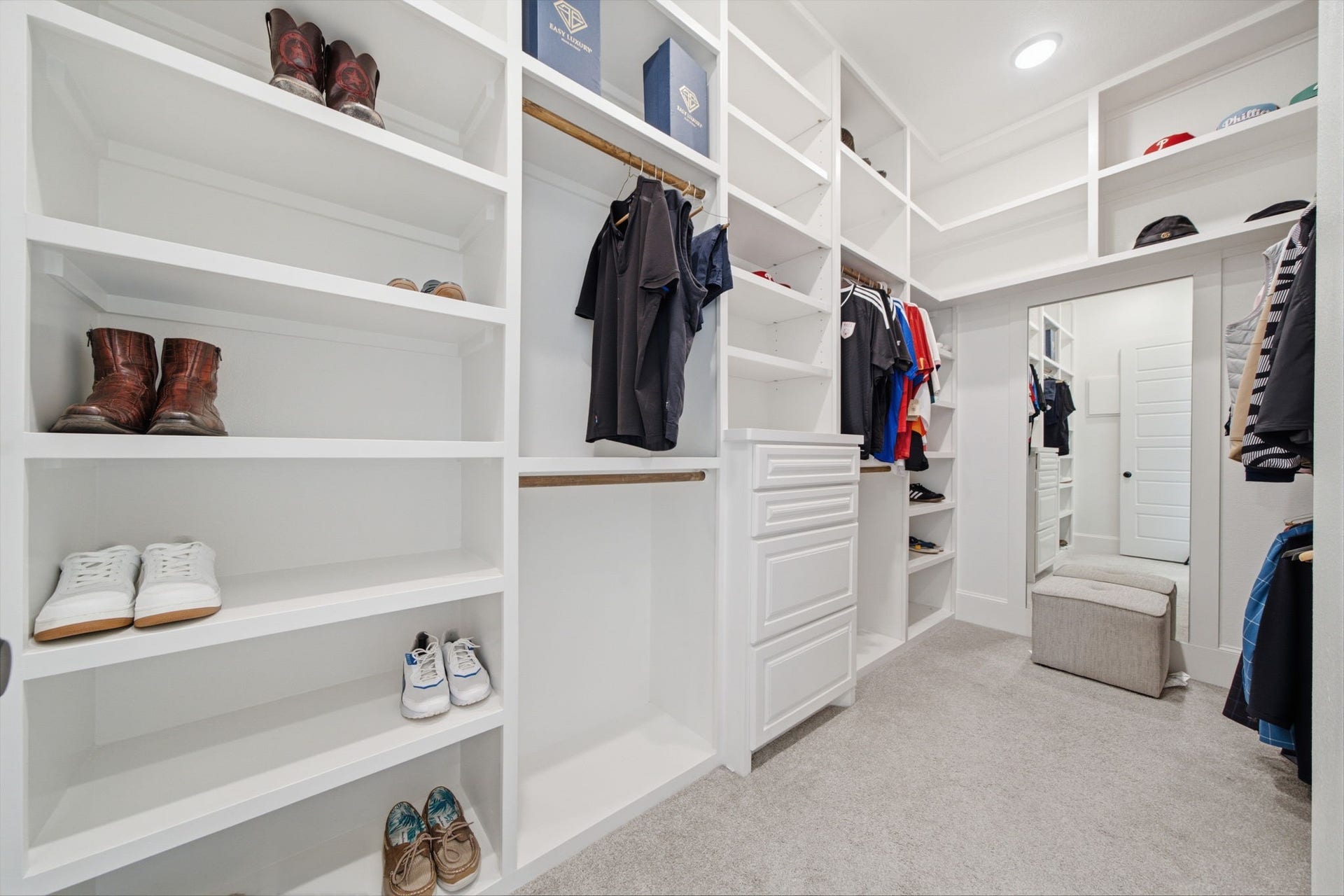6310 Star Light Court, Spring, TX 77386 Spacious walk-in closet with custom shelving, ample hanging space, and a convenient built-in dresser, perfect for organized storage.