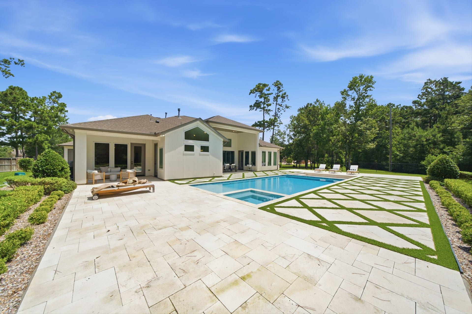 6310 Star Light Court, Spring, TX 77386 Elegant modern home with a spacious backyard featuring a pristine pool, stylish patio, and lush greenery, perfect for relaxation and entertaining.