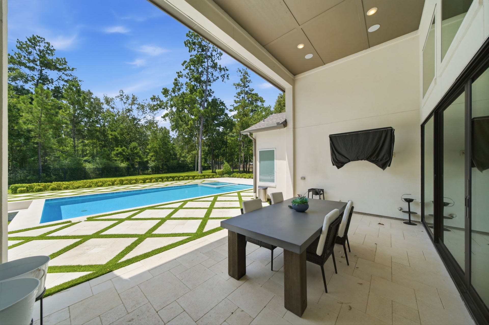 6310 Star Light Court, Spring, TX 77386 Discover seamless indoor-outdoor living with this elegant covered patio, overlooking a pristine pool and lush greenery.