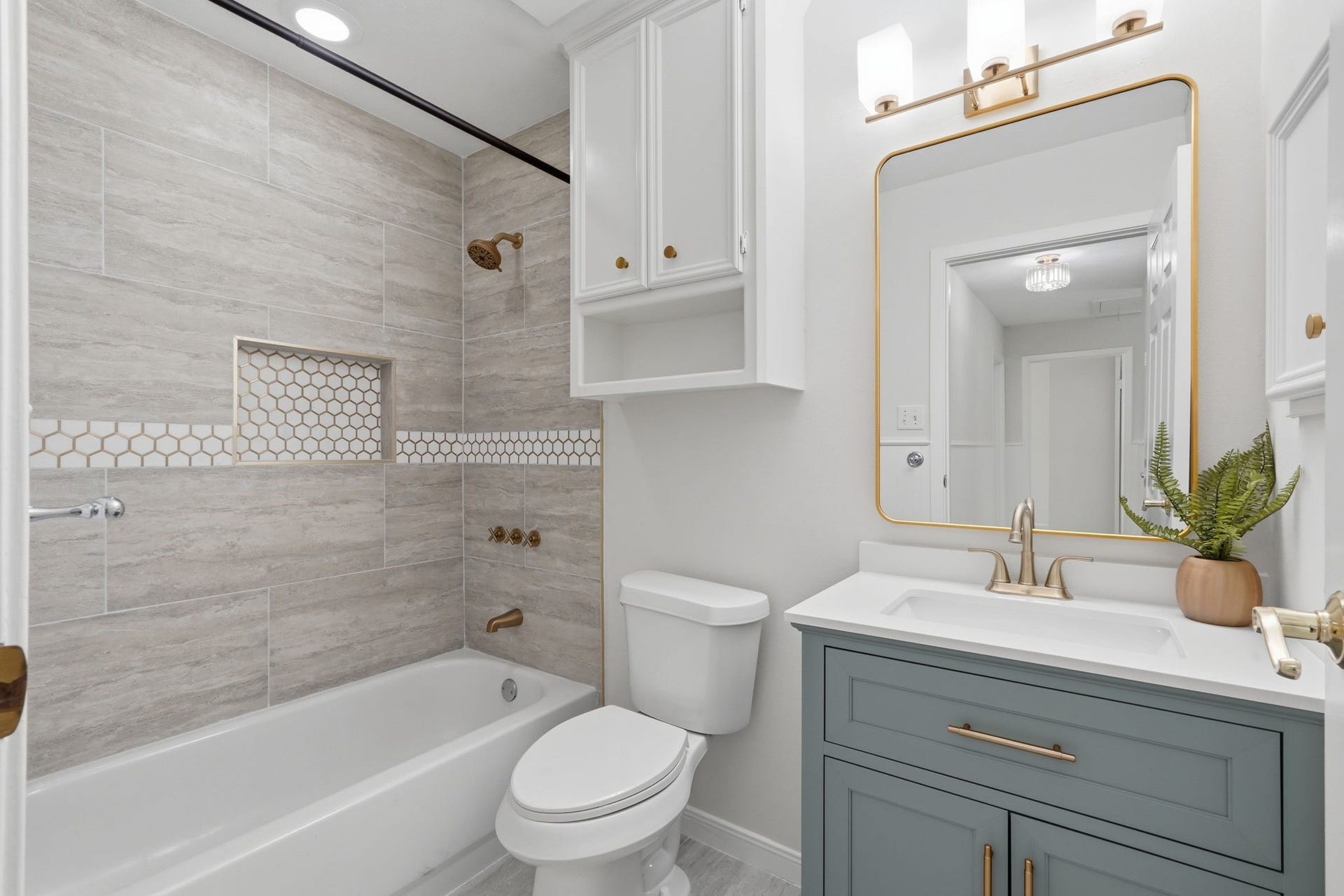 10916 Fawnlily Street, The Woodlands, TX 77380 At the end of the hallway is a modern, updated bathroom with storage for toiletries and a bath/shower combo.
