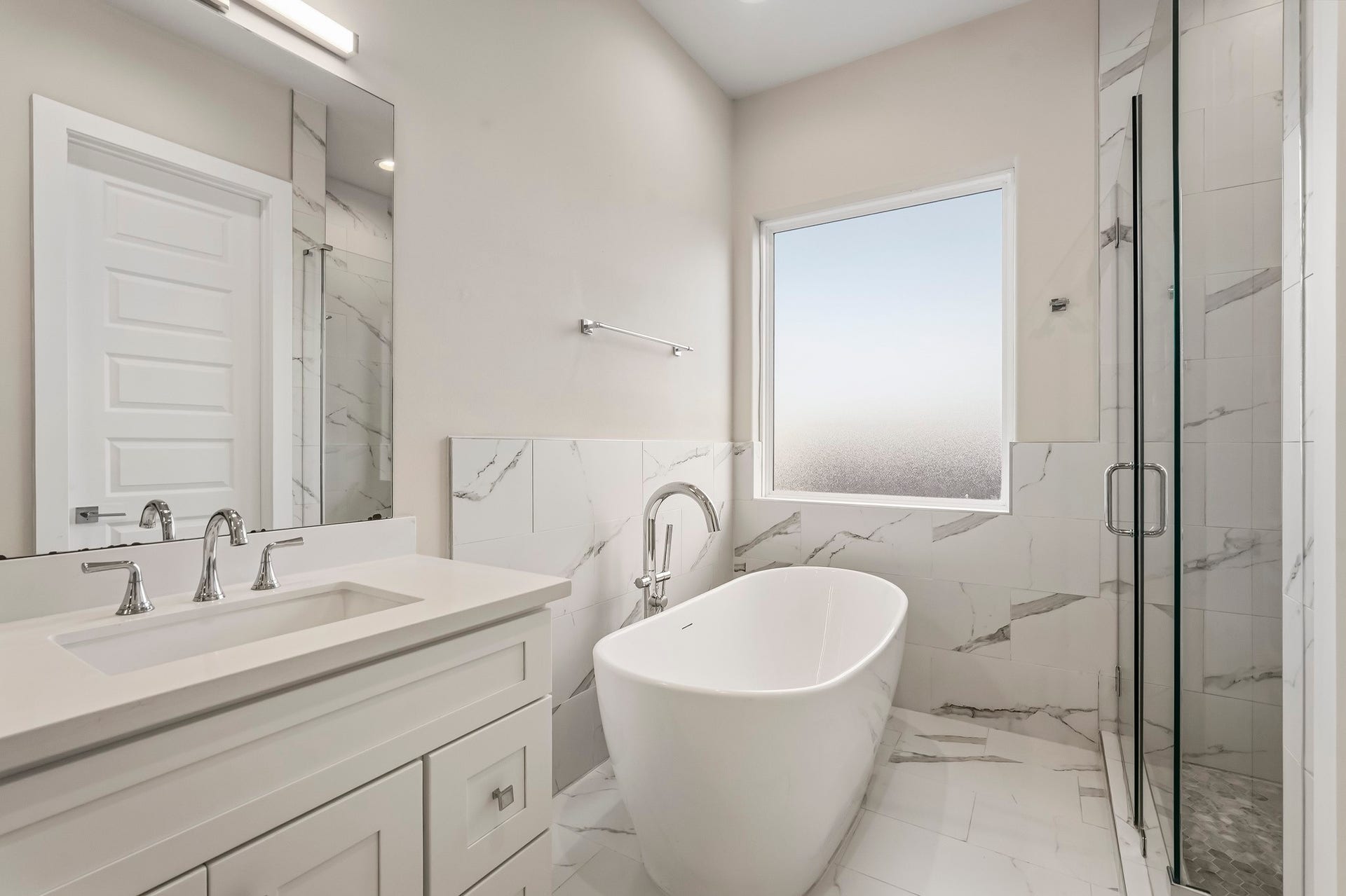 3109 Arlington Street, Houston, TX 77018 The spa-inspired design includes a freestanding soaking tub and separate frameless glass shower surrounded by elegant marble-look tile.
