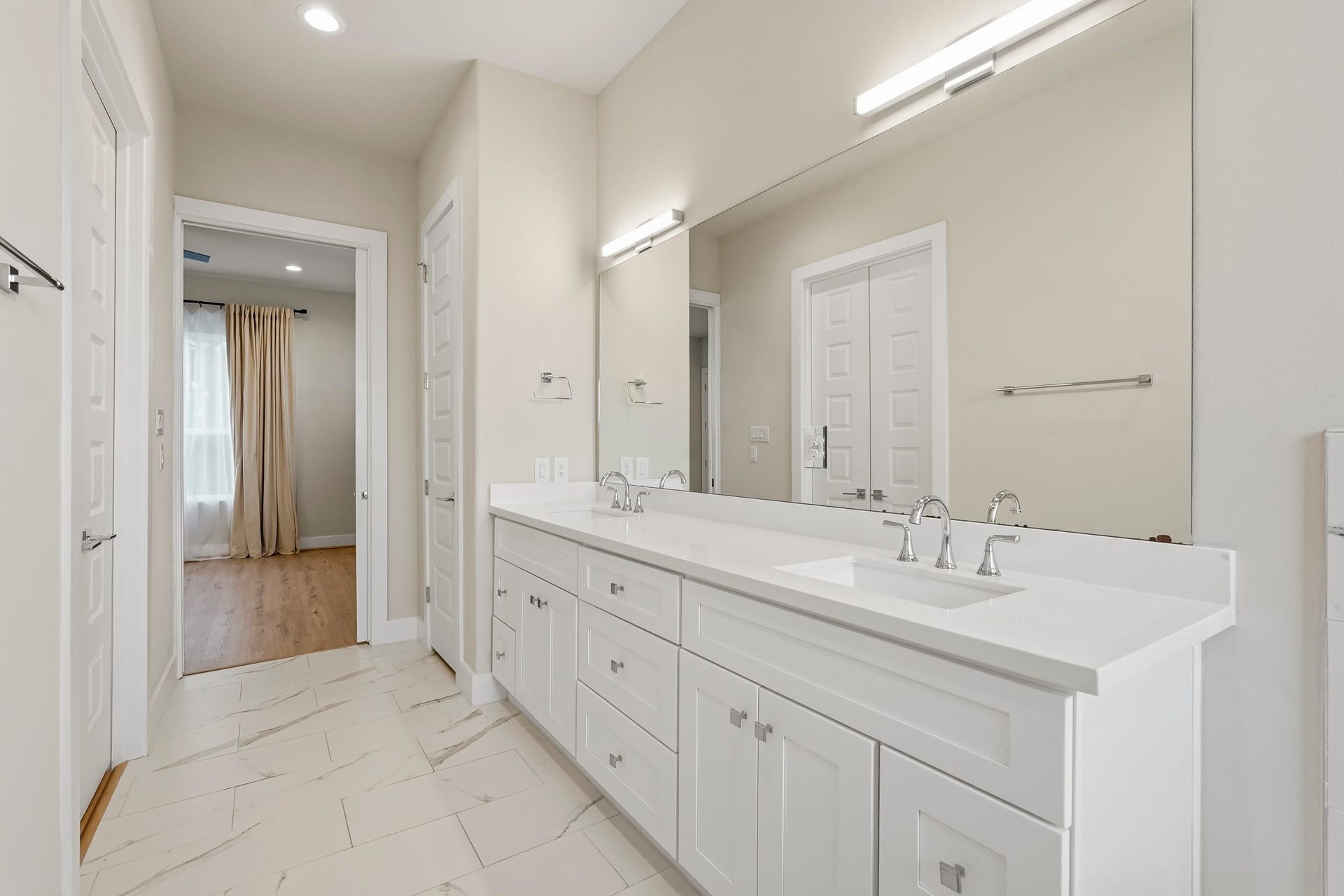 3109 Arlington Street, Houston, TX 77018 Luxurious primary bathroom featuring a long dual-sink vanity with abundant cabinetry, sleek countertops, and an expansive wall mirror.