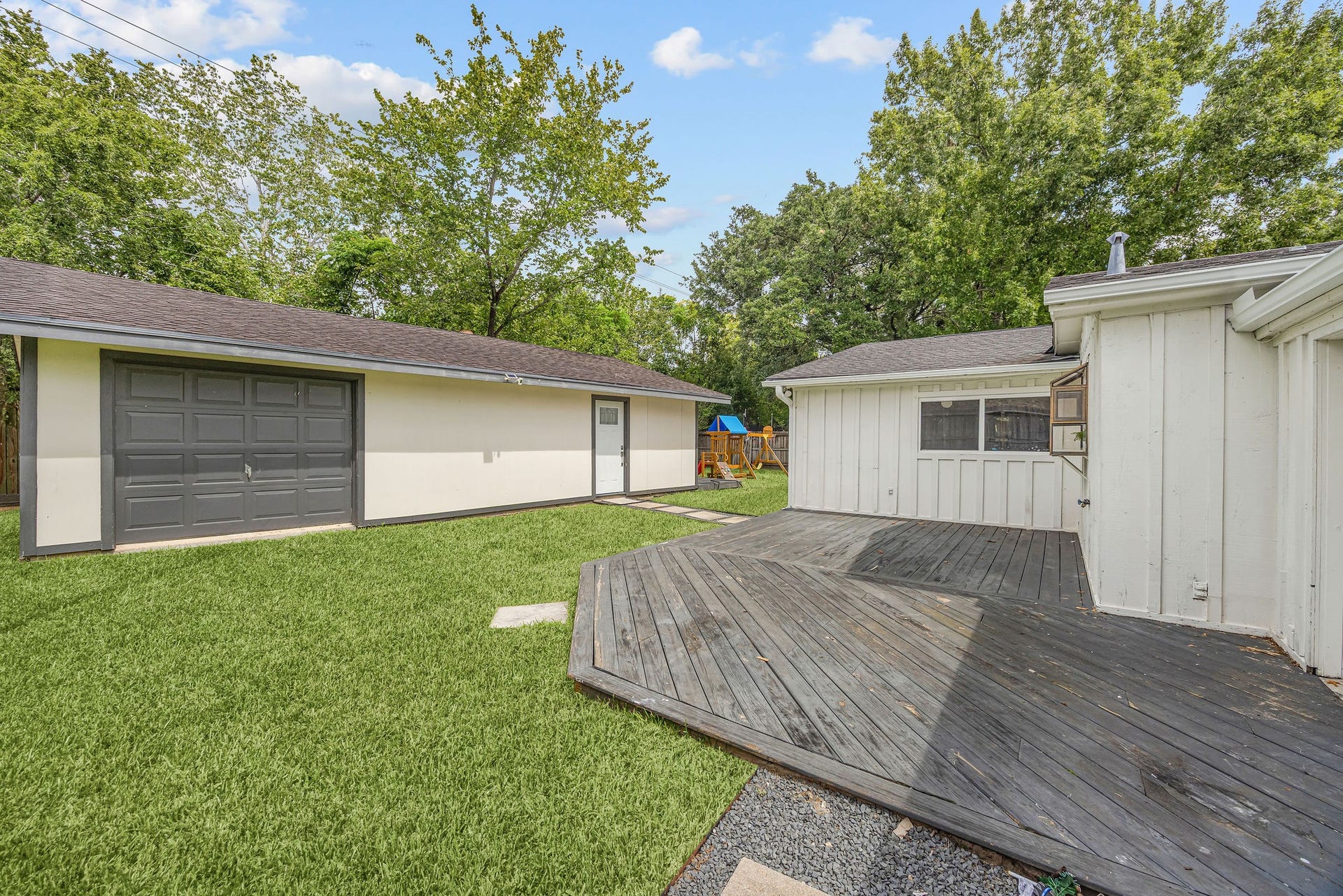 5250 Beechnut Street, Houston, TX 77096 Large backyard with deck and view of guest house and detached garage