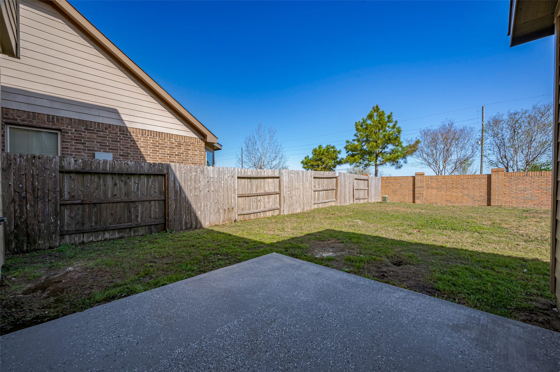 24114 Morrison Lane, Katy, TX 77493 Spacious backyard with a concrete patio, wooden fencing.
