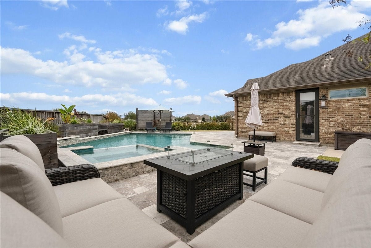 Your backyard paradise features a resort-style pool, spa, cedar pergola, covered patio, expansive travertine decking, and outdoor kitchen designed for entertaining!