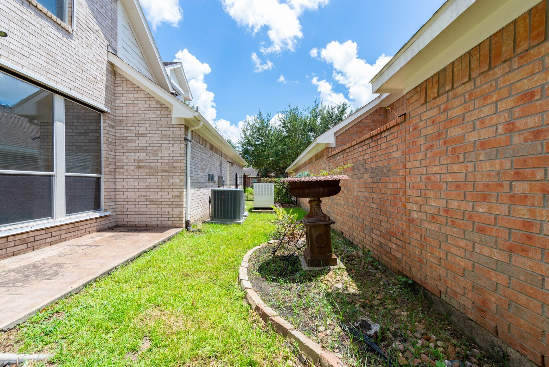 24922 Cinco Manor Lane, Katy, TX 77494 Side yard with green space, garden beds and a whole home generator.