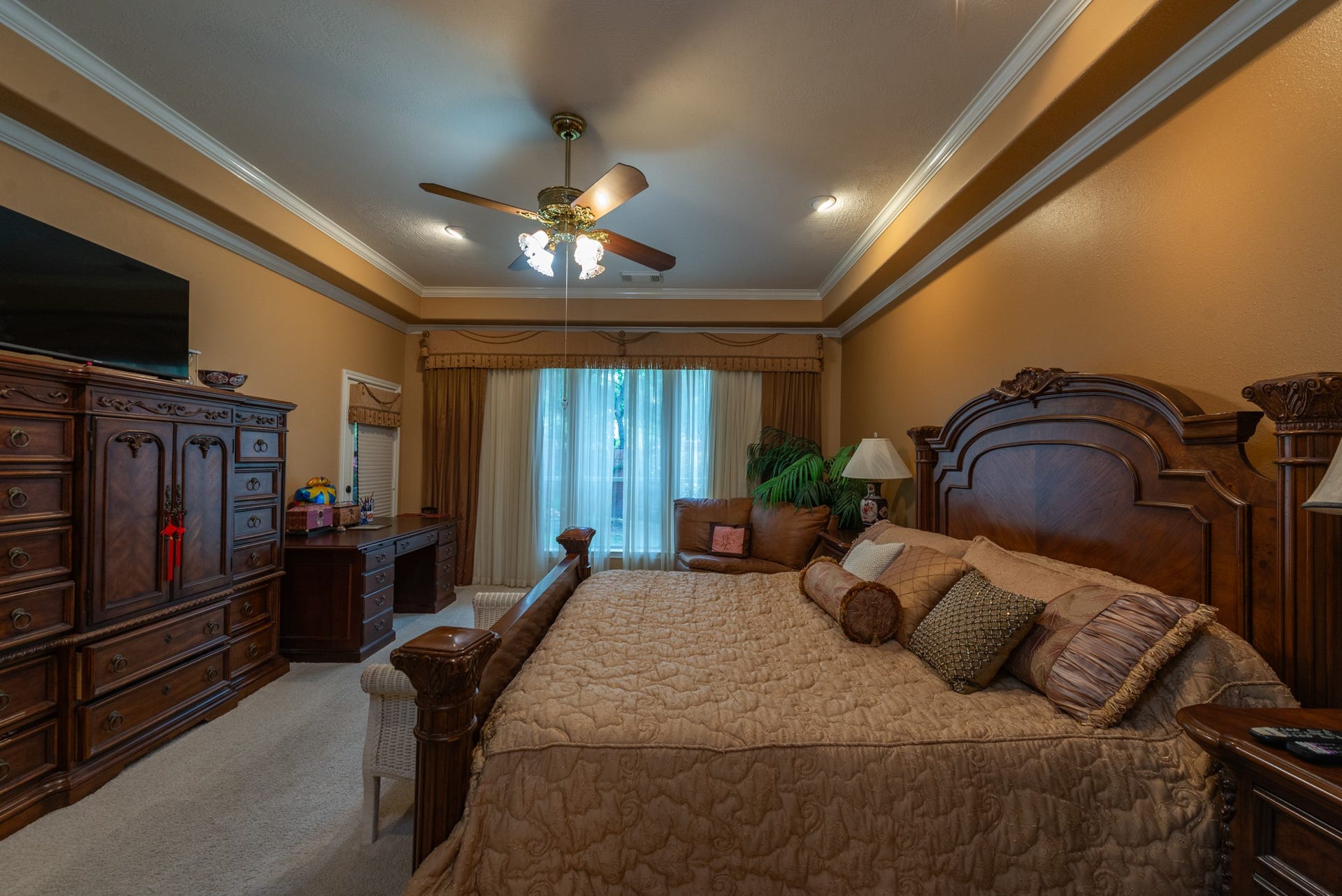 24922 Cinco Manor Lane, Katy, TX 77494 Generously sized primary bedroom with tray ceiling, crown molding, recessed lighting and room for a sitting or desk area.