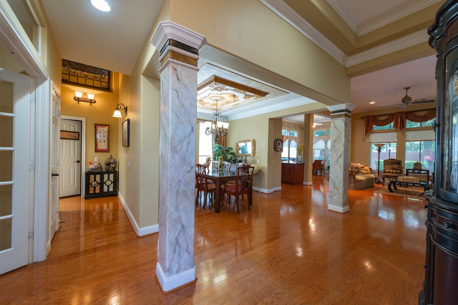 24922 Cinco Manor Lane, Katy, TX 77494 Step inside to hardwood flooring, decorative columns and an open layout connecting the main living and dining spaces.