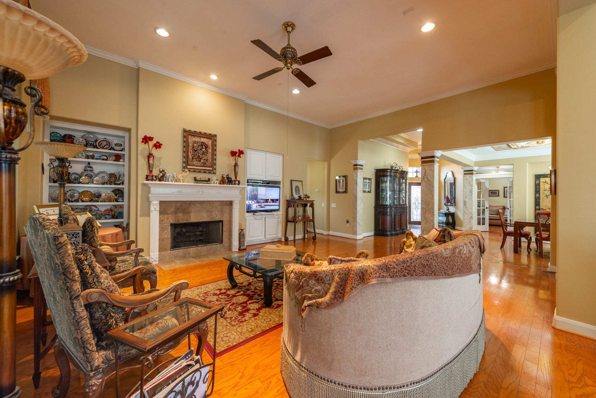 24922 Cinco Manor Lane, Katy, TX 77494 Another view of the generous living room showcasing the fireplace, built-in shelving, hardwood flooring and architectural details.