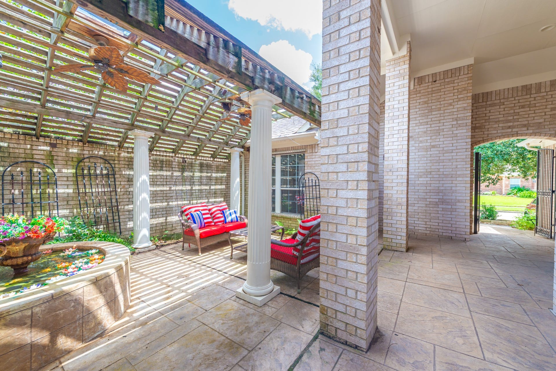 24922 Cinco Manor Lane, Katy, TX 77494 Another view of the private courtyard showcasing the fountain, pergola and covered walkway leading toward the gated entrance.