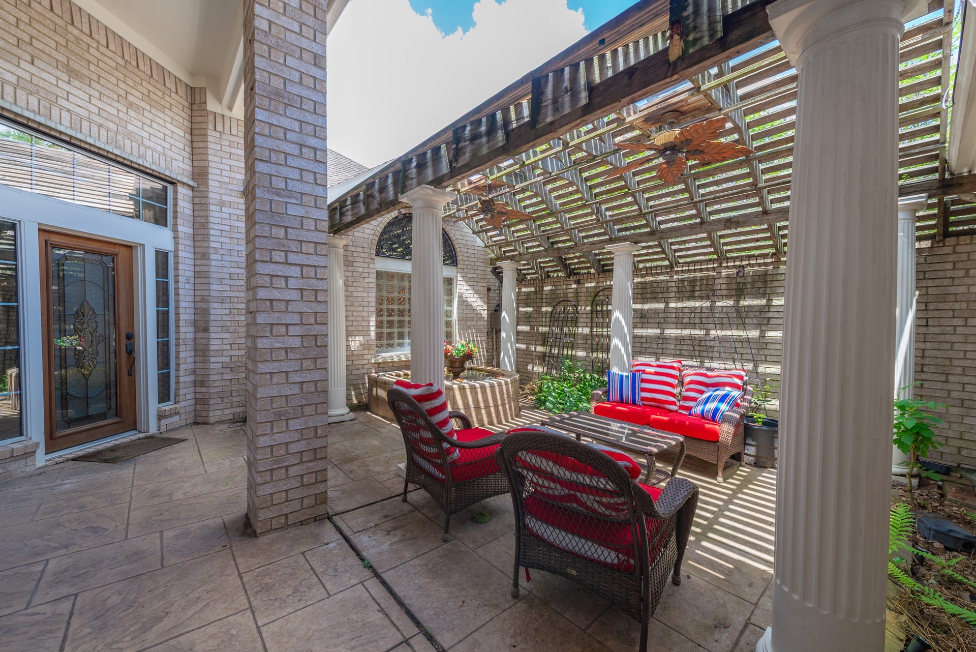 24922 Cinco Manor Lane, Katy, TX 77494 A covered portion of the courtyard offers a comfortable outdoor living space surrounded by classic architectural details.