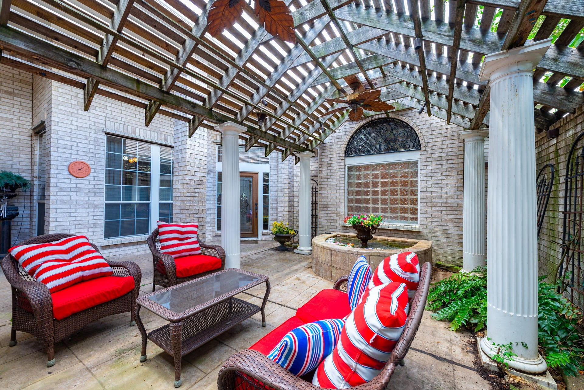 24922 Cinco Manor Lane, Katy, TX 77494 Pergola-covered seating area with decorative columns, ceiling fans and a tranquil fountain feature.