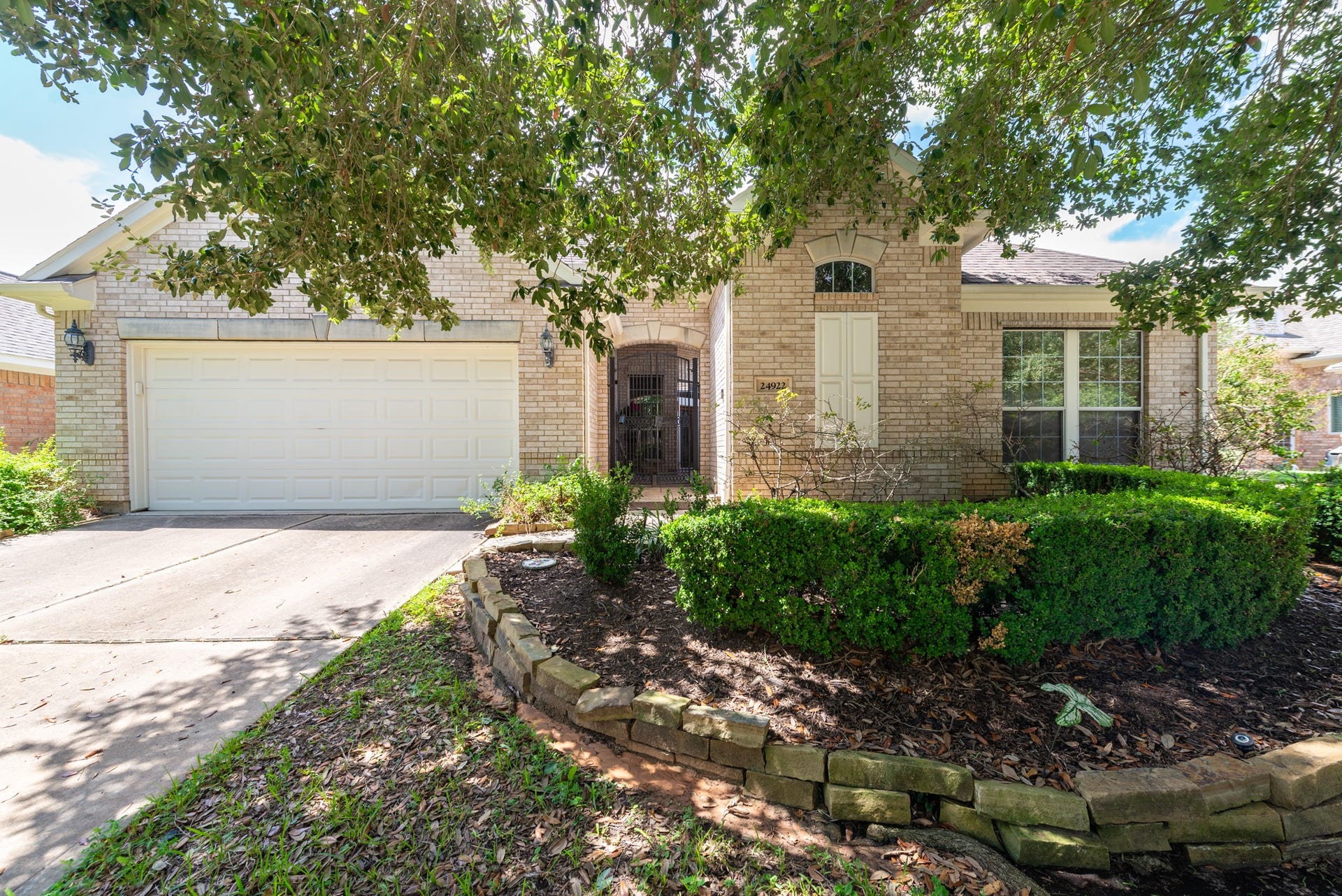24922 Cinco Manor Lane, Katy, TX 77494 Mature trees provide natural shade across the front of this Heritage Grand home with an attached two-car garage.
