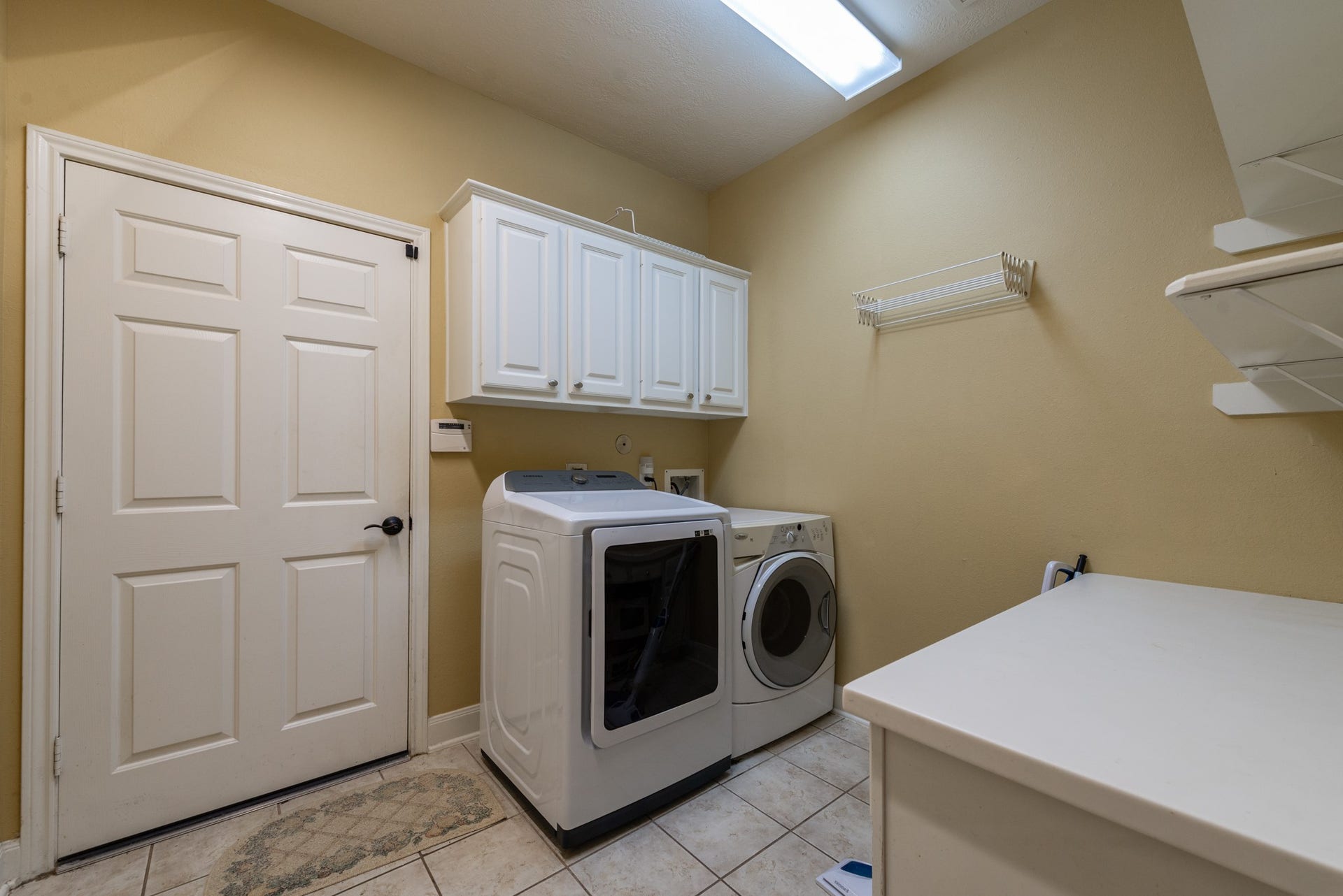 24922 Cinco Manor Lane, Katy, TX 77494 Spacious utility room with upper cabinetry, shelving, folding counter and room for a full-size washer and dryer.