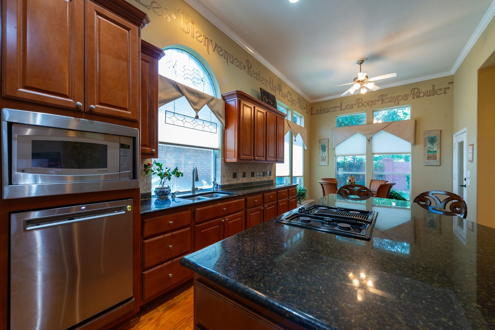24922 Cinco Manor Lane, Katy, TX 77494 Large center island with granite countertops, cooktop and bar seating anchors this well-appointed kitchen.