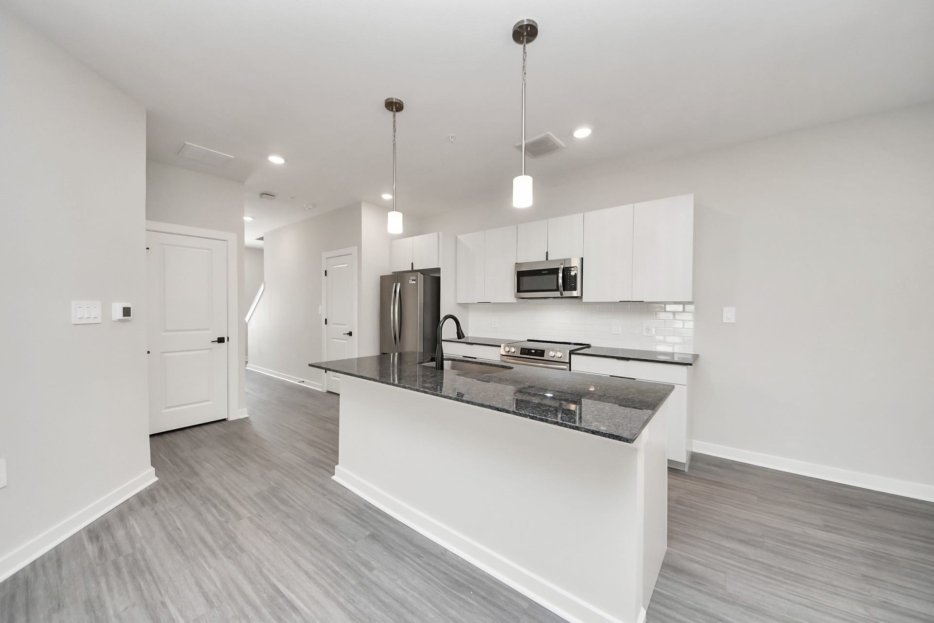 7711 Longmire Road, #97, Conroe, TX 77304 Boasting luxury finishes-stylish Island kitchen,granite counters,subway tile backsplash,ample custom cabinet space,stainless appliances,refrigerator,full size washer&dryer included,wood-like floors throughout,open concept floor plan.