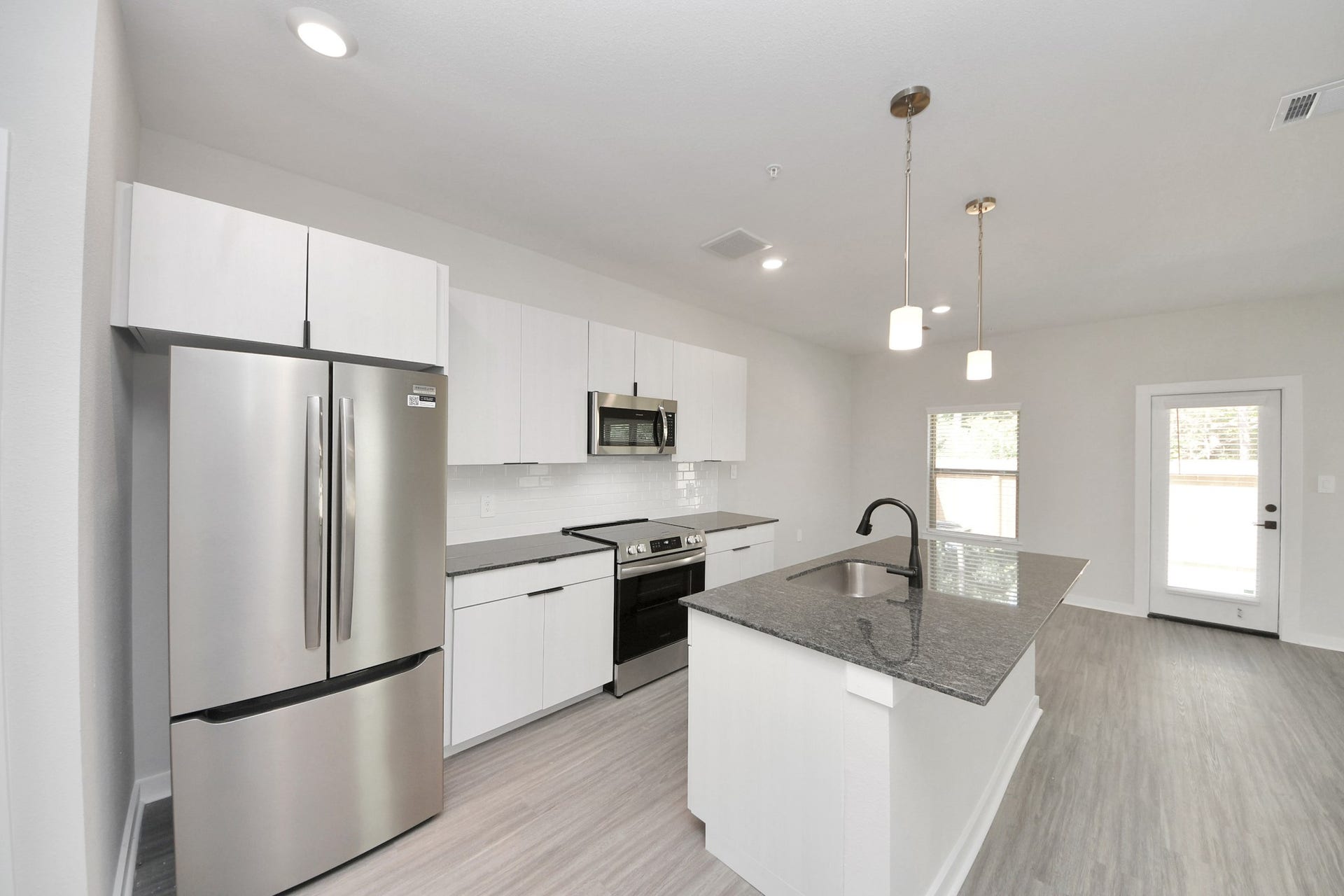 7711 Longmire Road, #97, Conroe, TX 77304 Boasting luxury finishes-stylish Island kitchen,granite counters,subway tile backsplash,ample custom cabinet space,stainless appliances,refrigerator,full size washer&dryer included,wood-like floors throughout,open concept floor plan.