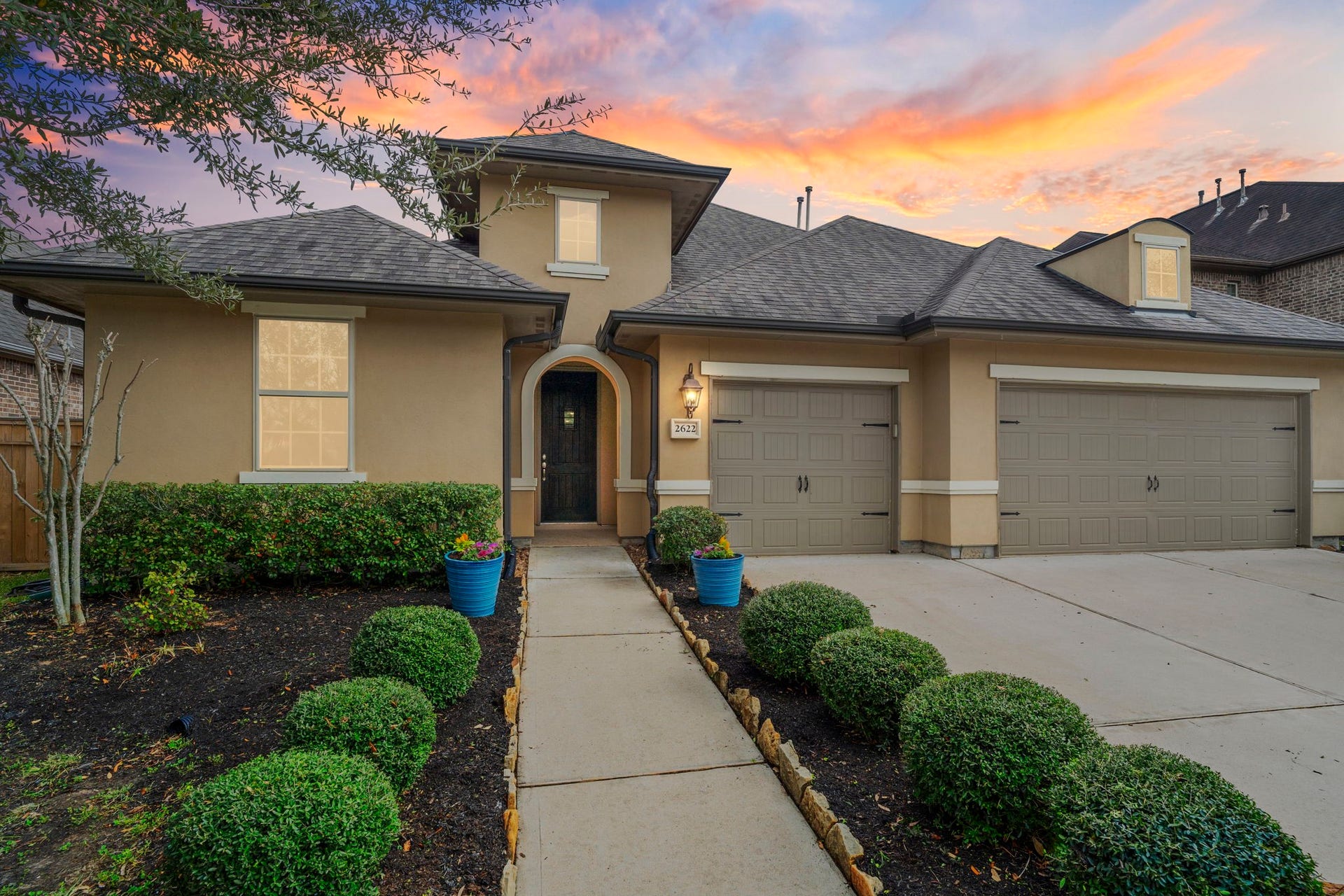 2622 Big Vine Court, Missouri City, TX 77459 Built by Shea Homes, this thoughtfully designed residence showcases timeless stucco architecture, a graceful arched entry, and meticulously manicured landscaping that frames the inviting approach.