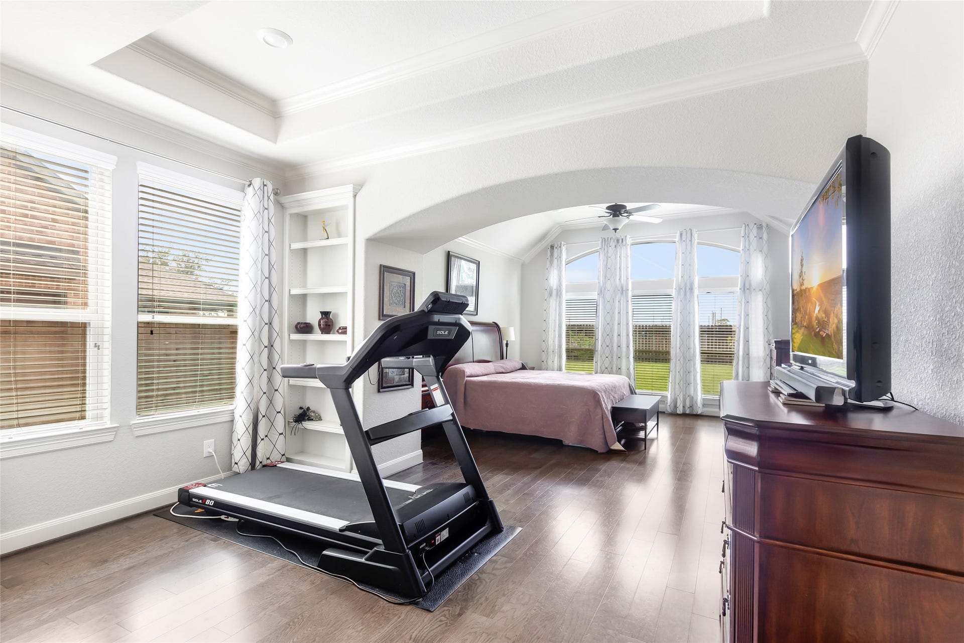 18931 Wild Thornberry Drive, Tomball, TX 77377 Master bedroom with great view of the backyard and 5' oak hardwood flooring. Sitting area has tray ceiling and built-in shelving for books and decor.