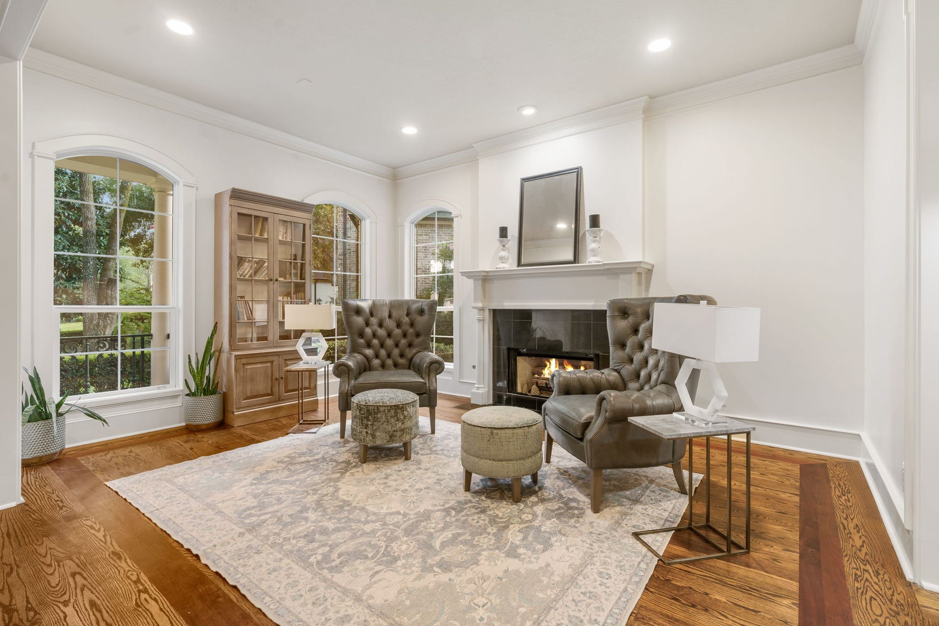 186 Sentinel Point Court, The Woodlands, TX 77382 The receiving room is open, airy with a trio of windows providing generous natural light and views of the lush, manicured front yard. A stately gas fireplace sets the tone for this flexible space.
