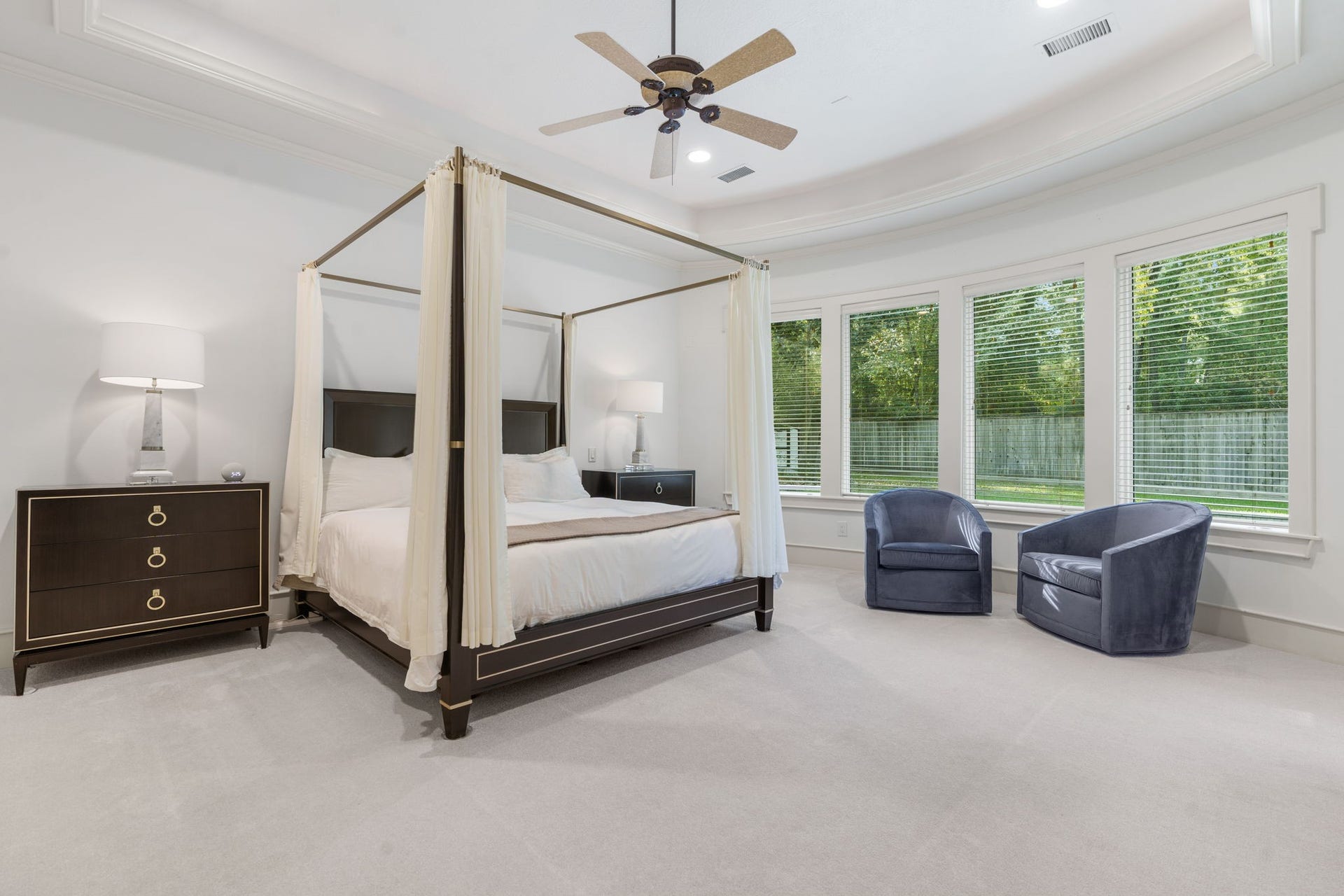 186 Sentinel Point Court, The Woodlands, TX 77382 Primary retreat boasts a wall of windows taking in a relaxing green backdrop.
