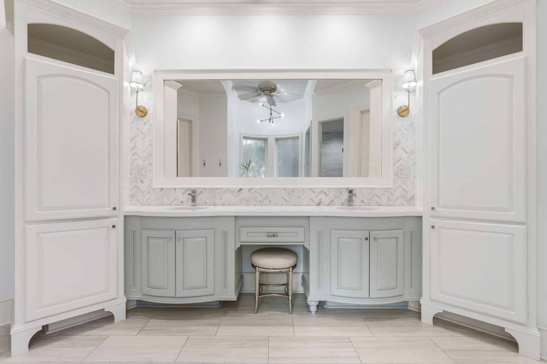 186 Sentinel Point Court, The Woodlands, TX 77382 A peaceful palette of soft grays, crisp whites, and delicate herringbone tiles transforms this primary bathroom into a spa-like sanctuary.