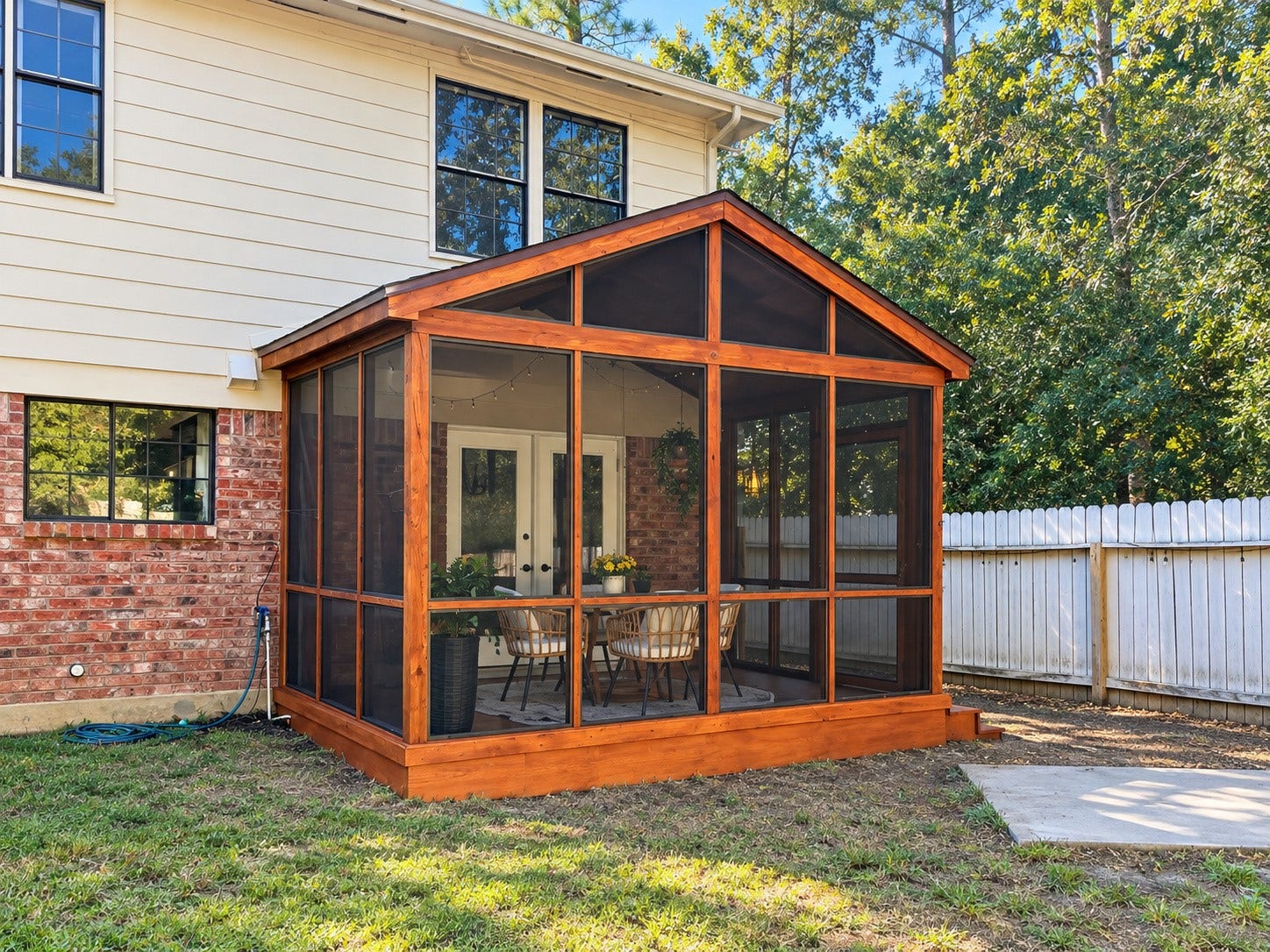 Charming screened-in porch with vaulted ceiling and warm wood finishes, perfect for relaxing or entertaining.