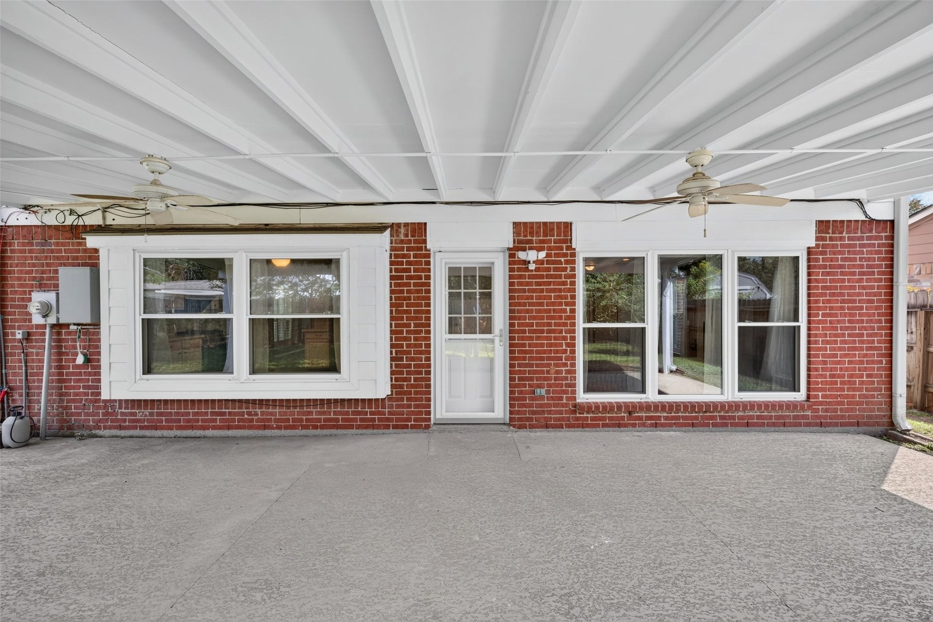 3507 Santa Rosa Lane, Sugar Land, TX 77478 A spacious covered patio designed for effortless outdoor living, complete with ceiling fans and ample space for comfortable seating and alfresco dining.