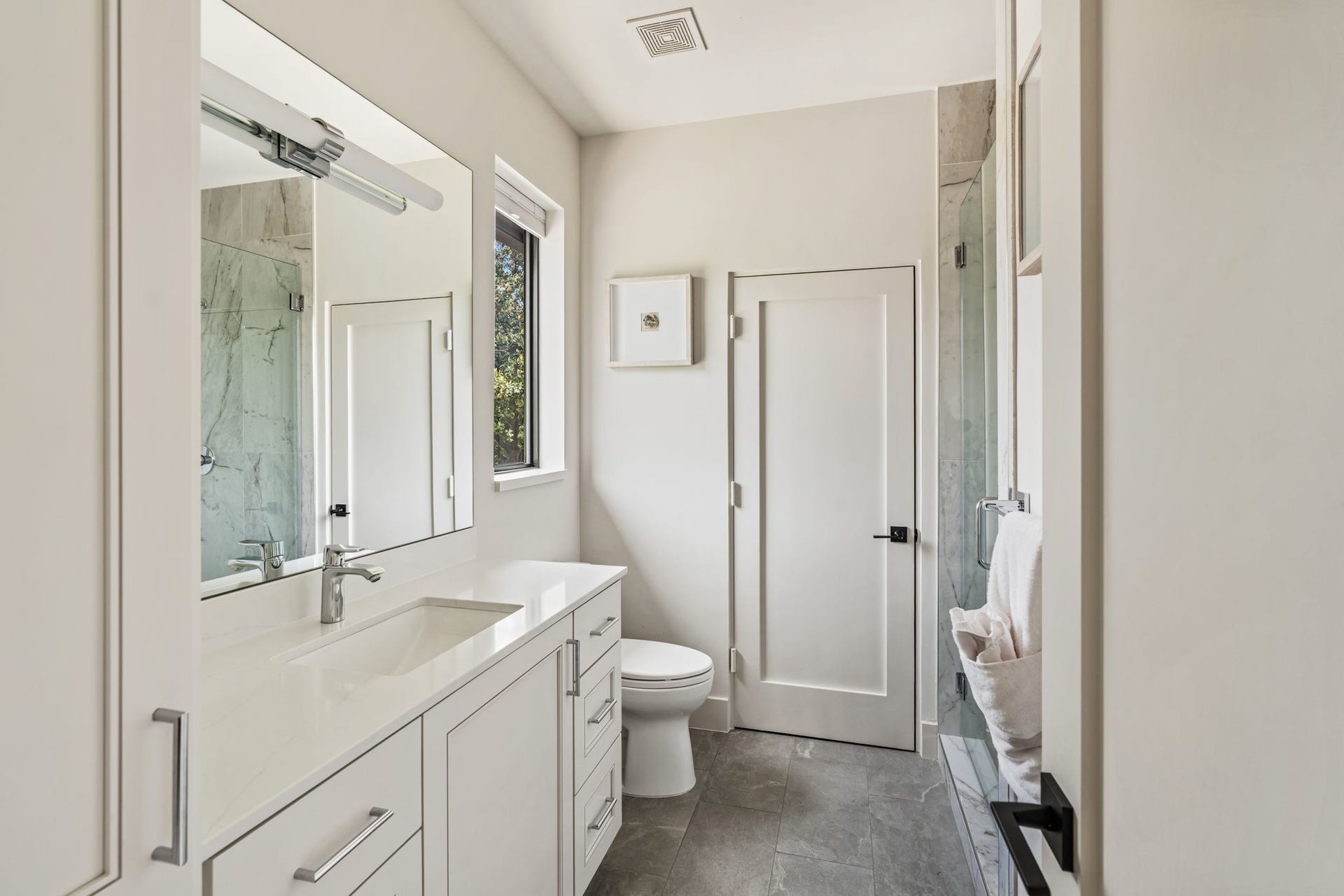 4638 Merwin Street, Houston, TX 77027 The ensuite bath features designer lighting and a spacious glass-enclosed walk-in shower.