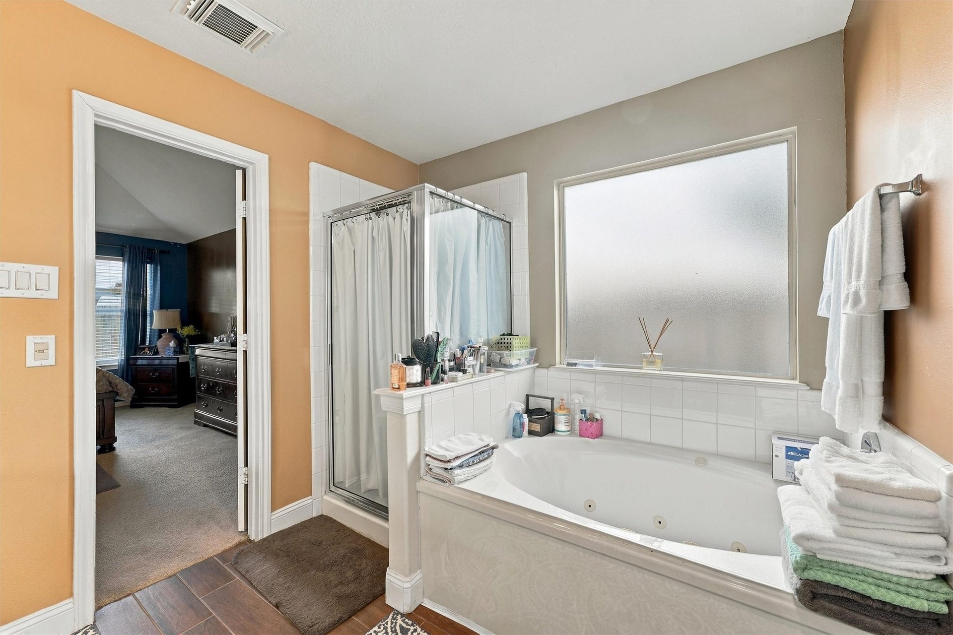 18931 Bonners Park Circle, Katy, TX 77449 Spacious bathroom featuring a luxurious jetted tub, separate glass-enclosed shower, and a frosted window for privacy.