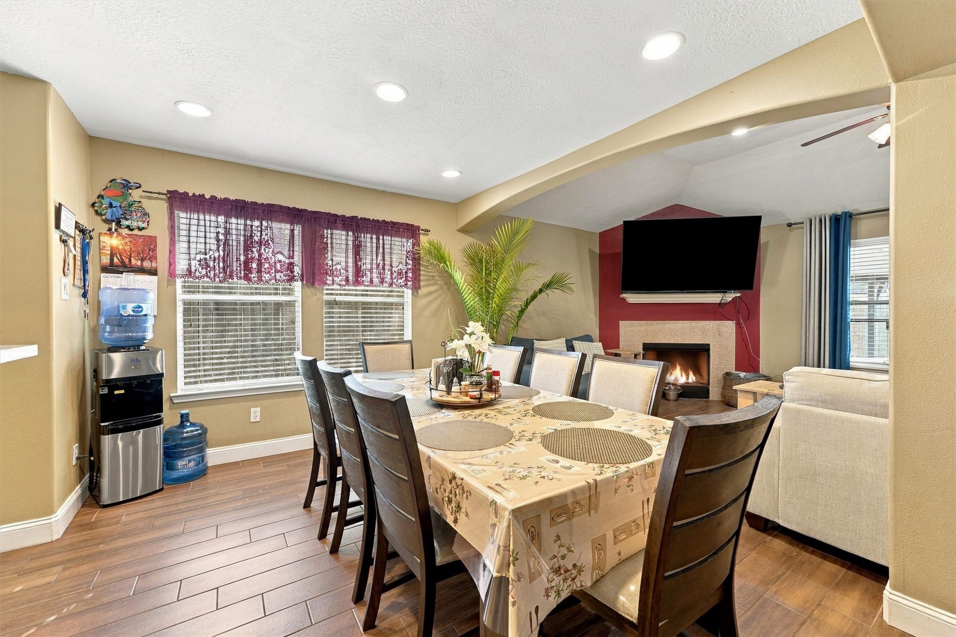 18931 Bonners Park Circle, Katy, TX 77449 Spacious dining area and a cozy living room featuring a fireplace and mounted TV, perfect for entertaining.